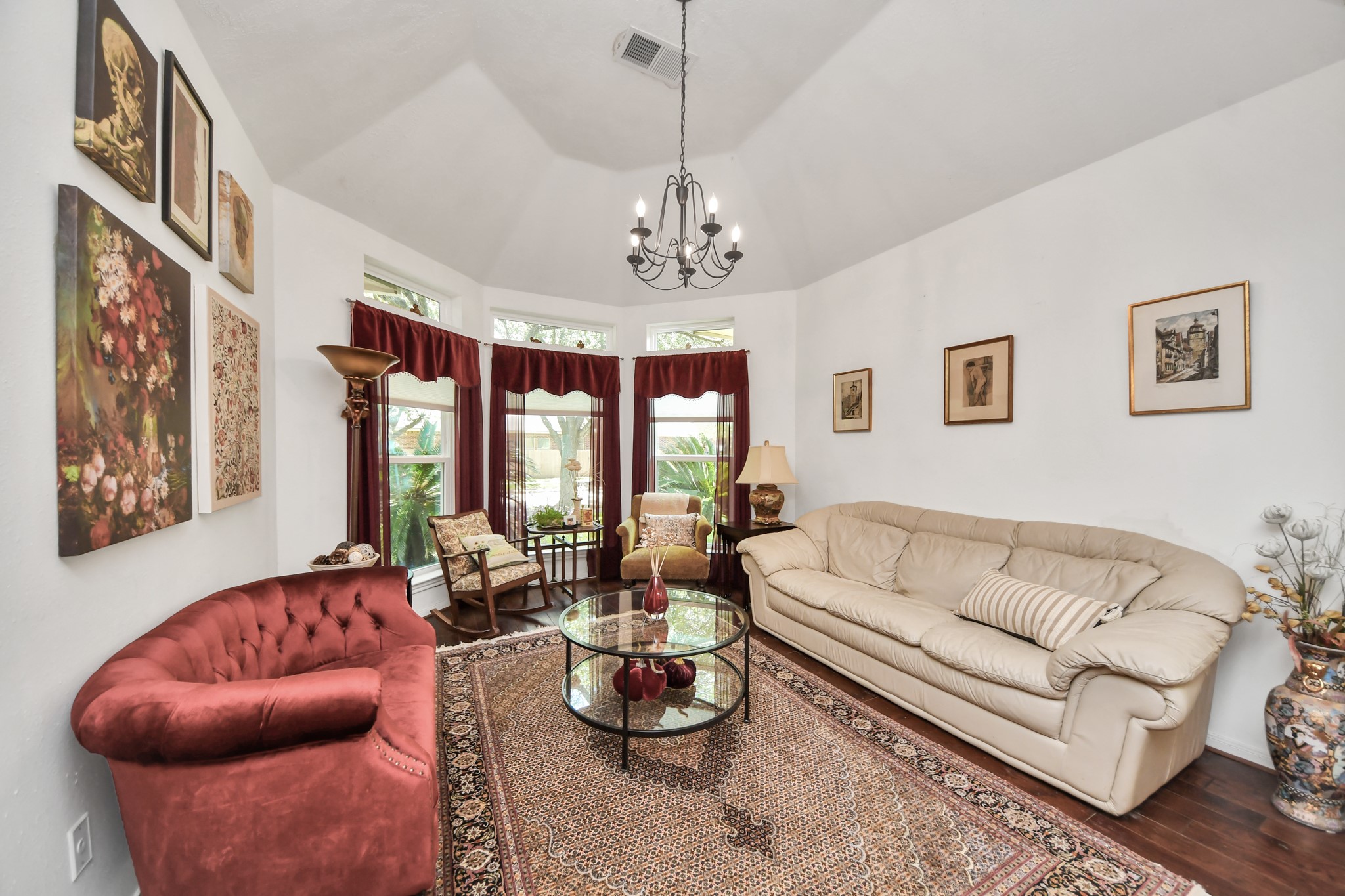 Formal living room with a raised ceiling and a curved wall of windows.
