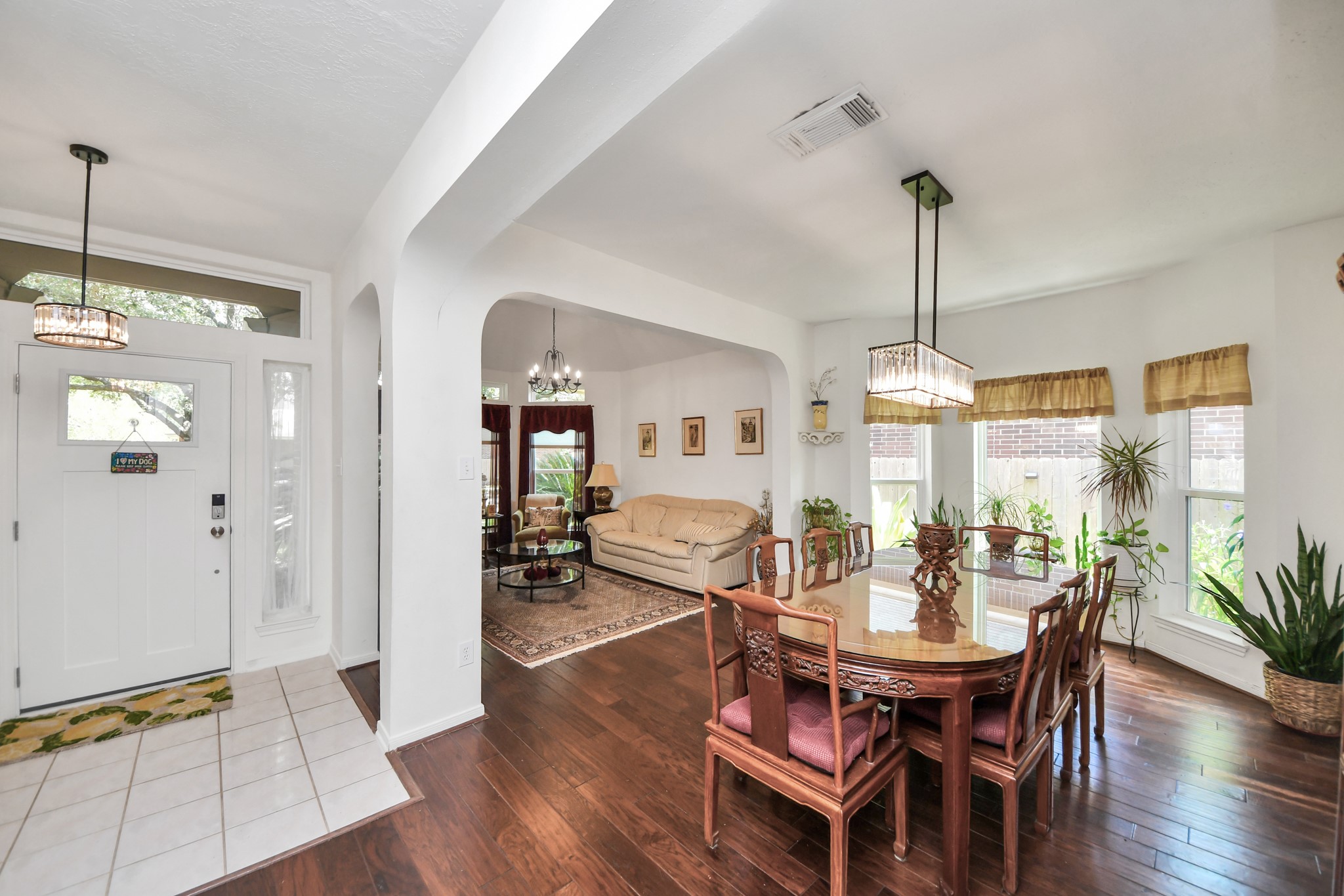 The front entry opens to the formal dining and living areas through beautiful arched openings.