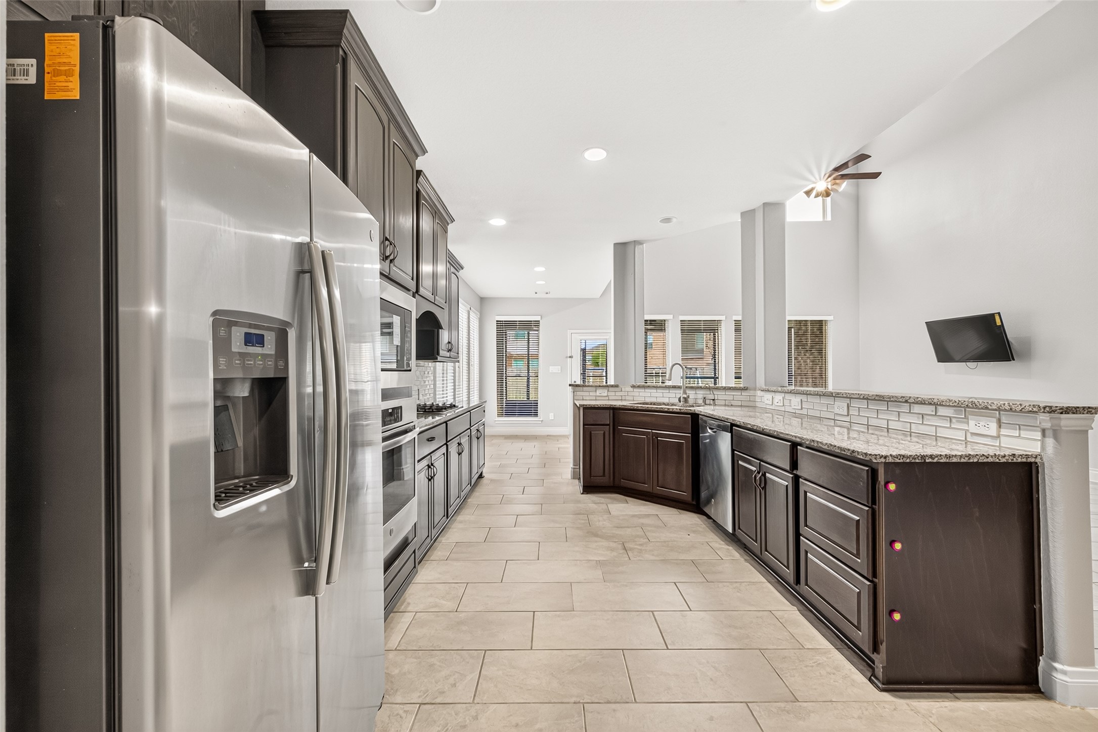 Beautiful kitchen featuring built-in appliances, granite countertops, and elegant cabinetry with crown molding, creating a perfect blend of style, functionality, and timeless appeal.