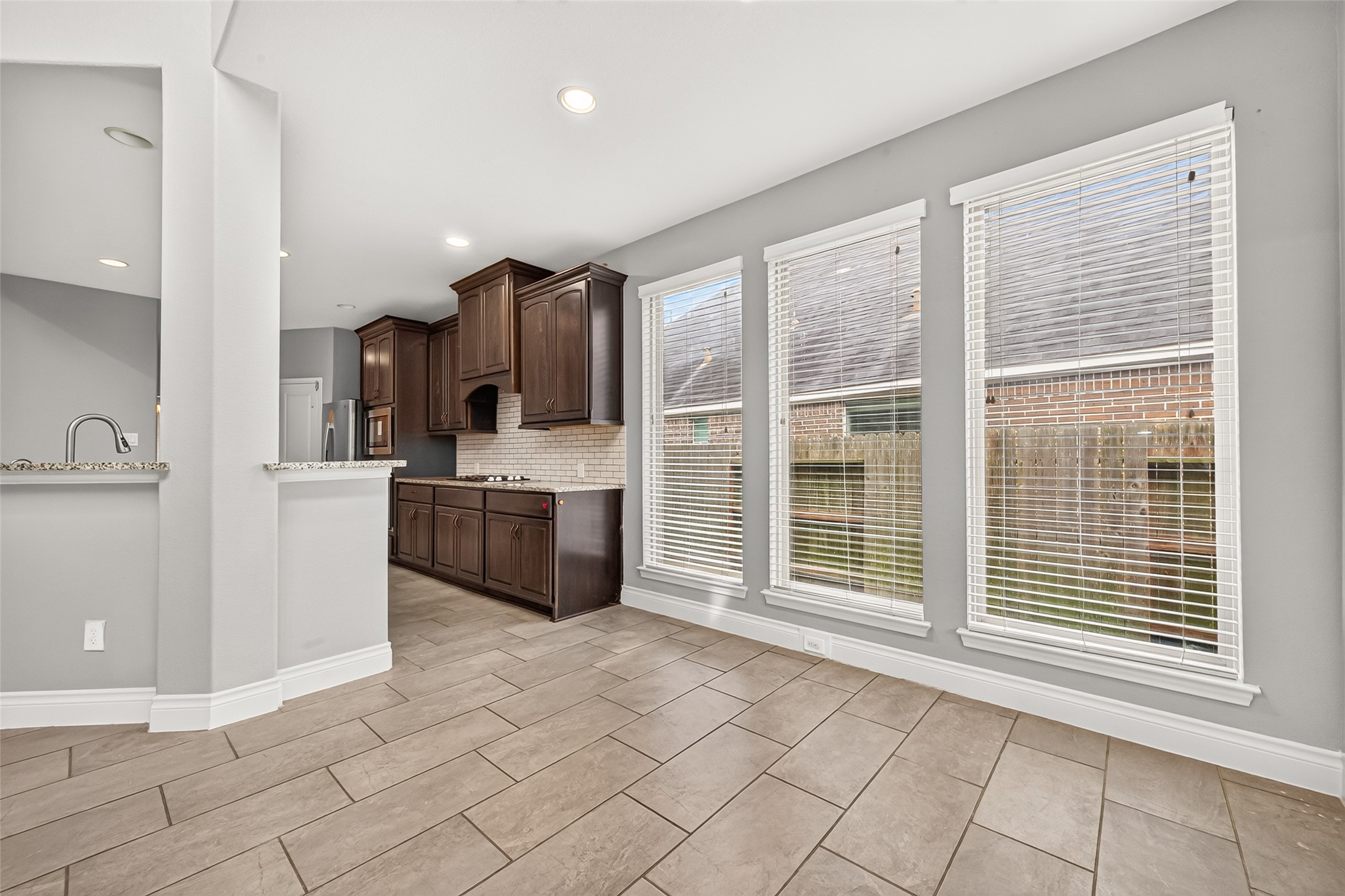 Bright breakfast area featuring a wall of windows that fills the space with natural light, creating the perfect setting for casual dining and morning coffee