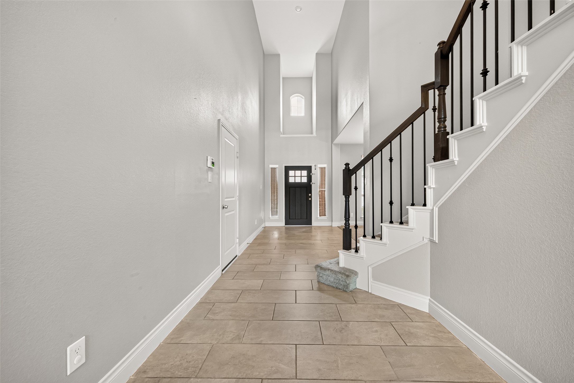 Grand high-ceiling entry bathed in natural light, creating a bright and welcoming first impression with an elegant sense of space