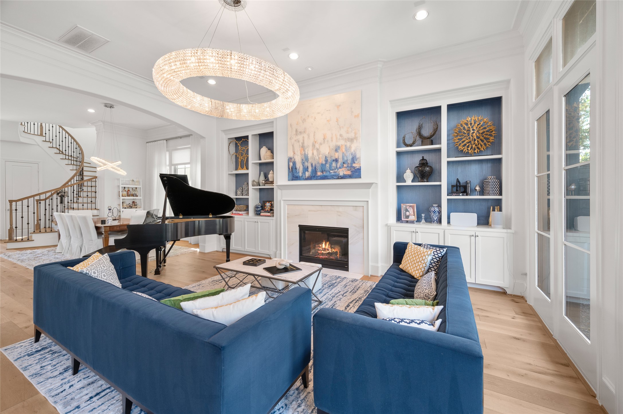 Open-concept layout connects the living room and breakfast area, with natural light filtering through expansive glass doors and windows.