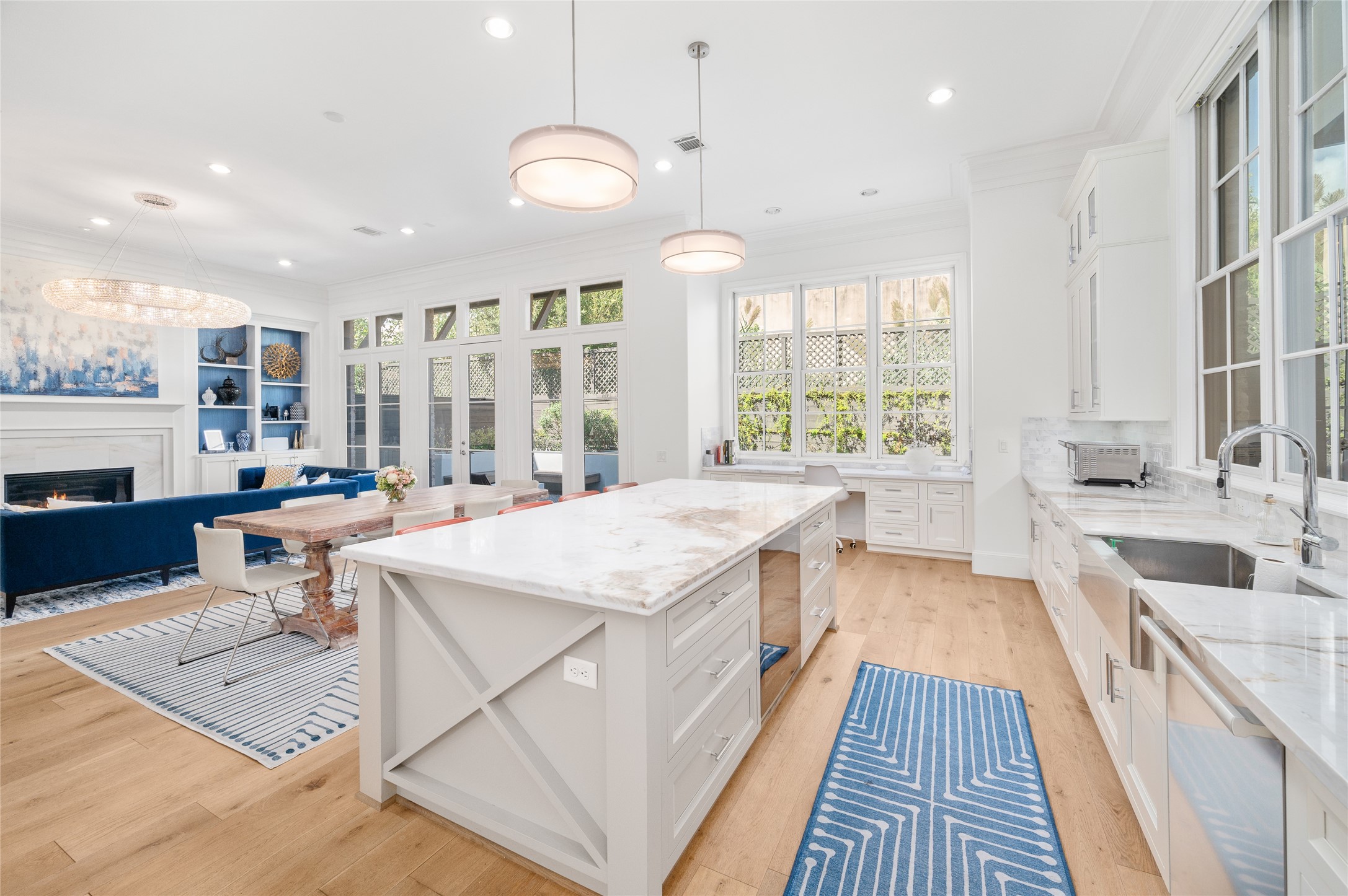 The kitchen's central island overlooks the breakfast area and adjoining living room, creating an open, connected floor plan with views toward the backyard space.