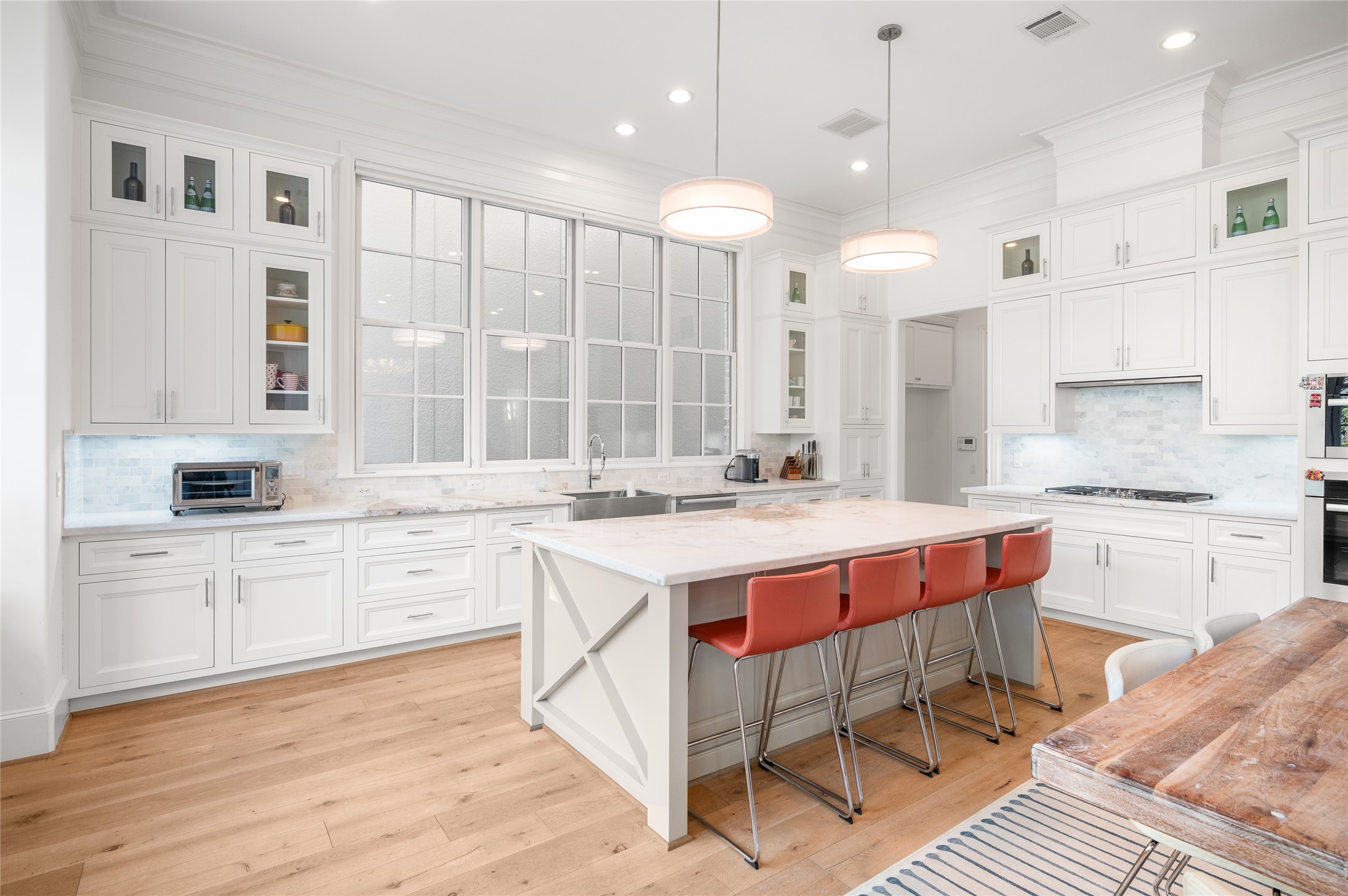 Chef's island kitchen with marble counter tops, marble backsplash, and Miele appliances.