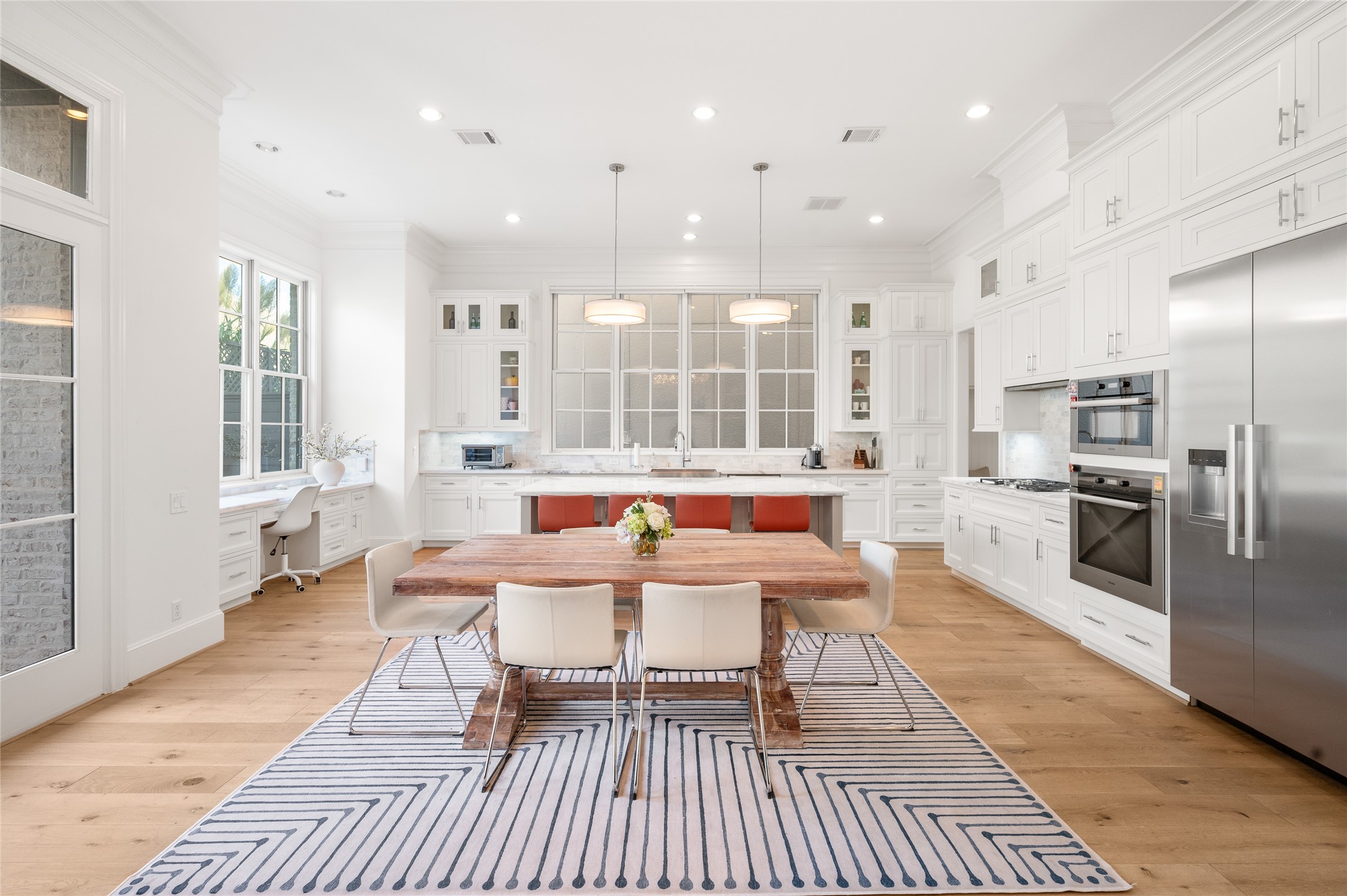 Another view of the chef's island kitchen, breakfast area, and built-in work space.