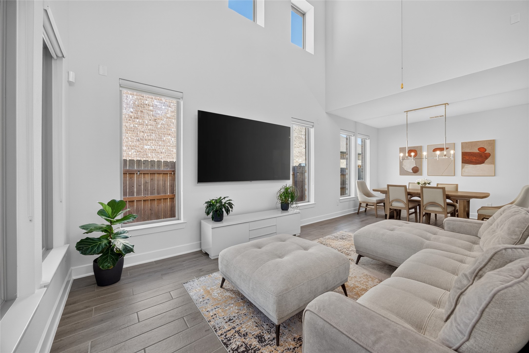 This view highlights the family rooms generous wall space, tall windows and connection to the dining area. The open arrangement offers flexibility for a spacious seating group and entertainment setup. Natural light and a soft, neutral palette create a comfortable backdrop for everyday living. This view highlights the family rooms generous wall space, tall windows and connection to the dining area. The open arrangement offers flexibility for a spacious seating group and entertainment setup. Natural light and a soft, neutral palette create a comfortable backdrop for everyday living.