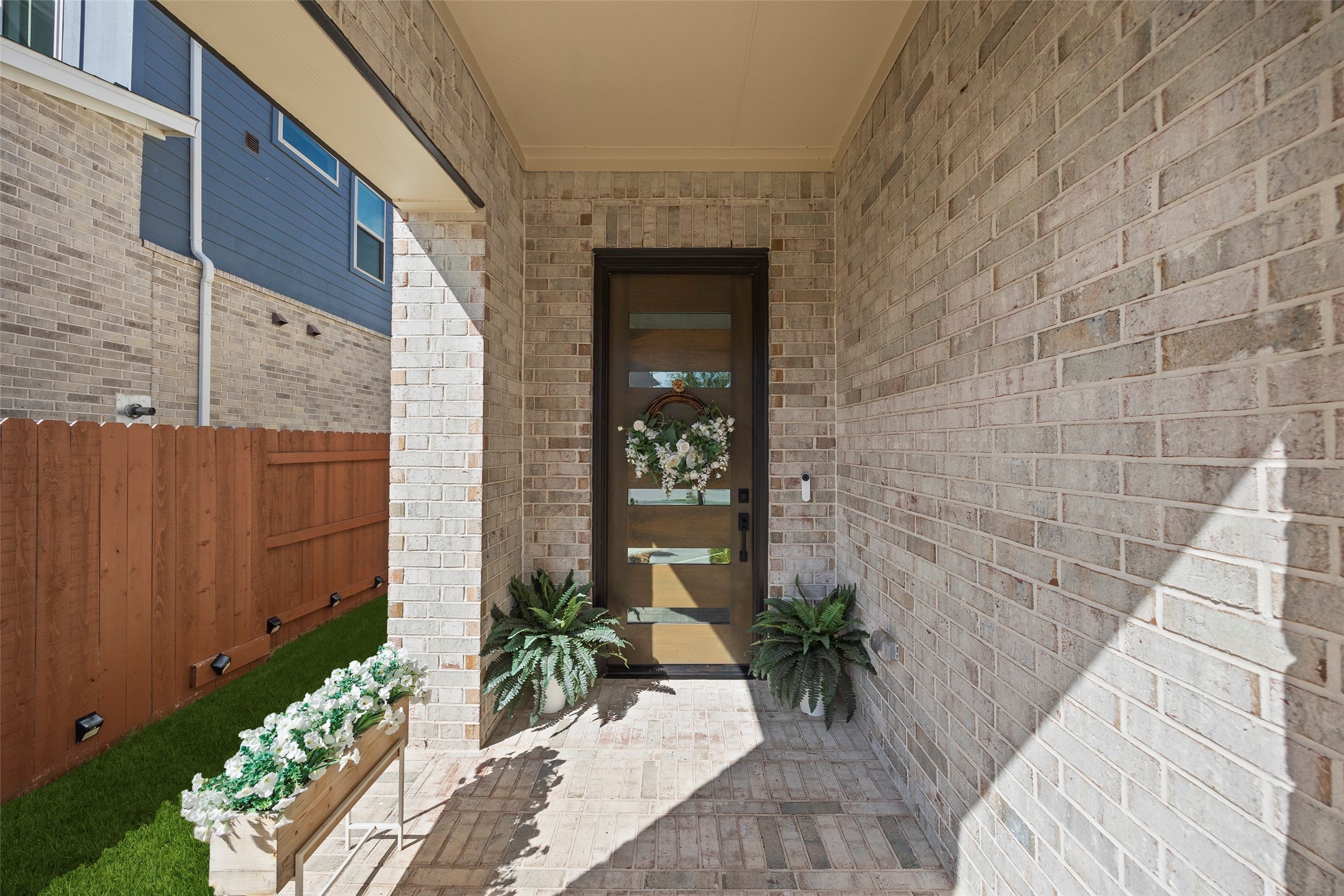 The recessed entry provides a protected arrival space, with room for planters and seasonal accents to personalize the entrance.