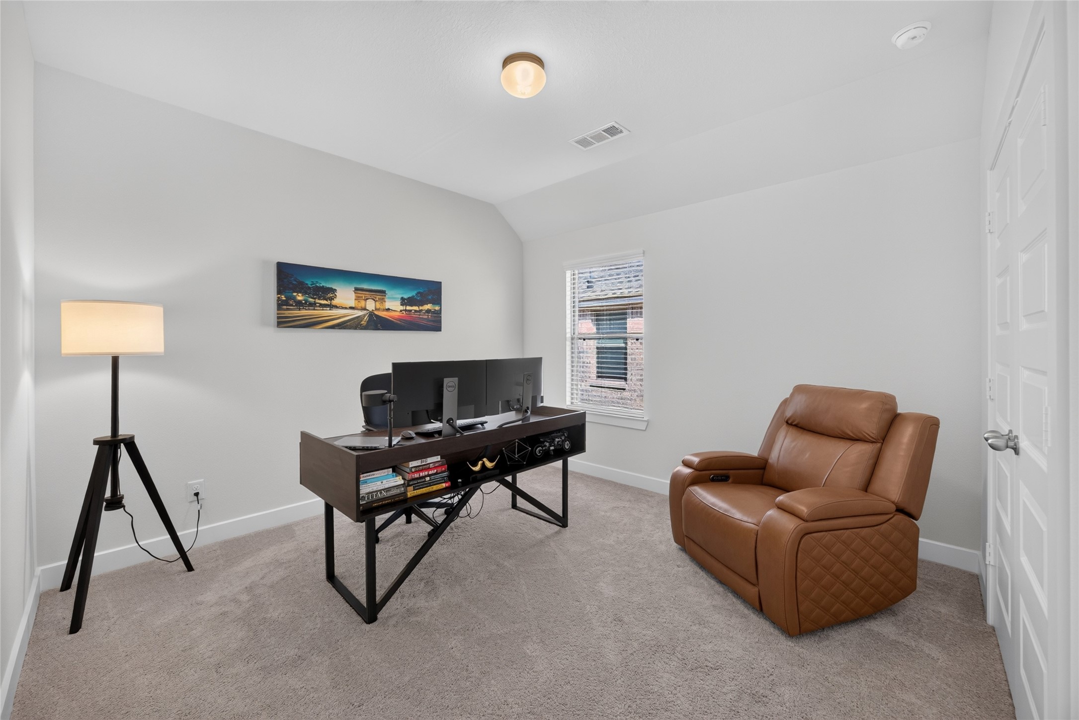 Currently furnished as a home office, this upstairs bedroom illustrates an option for working or studying from home. The room accommodates a desk and additional seating, with natural light from the window. As one of the homes four bedrooms, it can also serve as a guest room or dedicated sleeping space.
