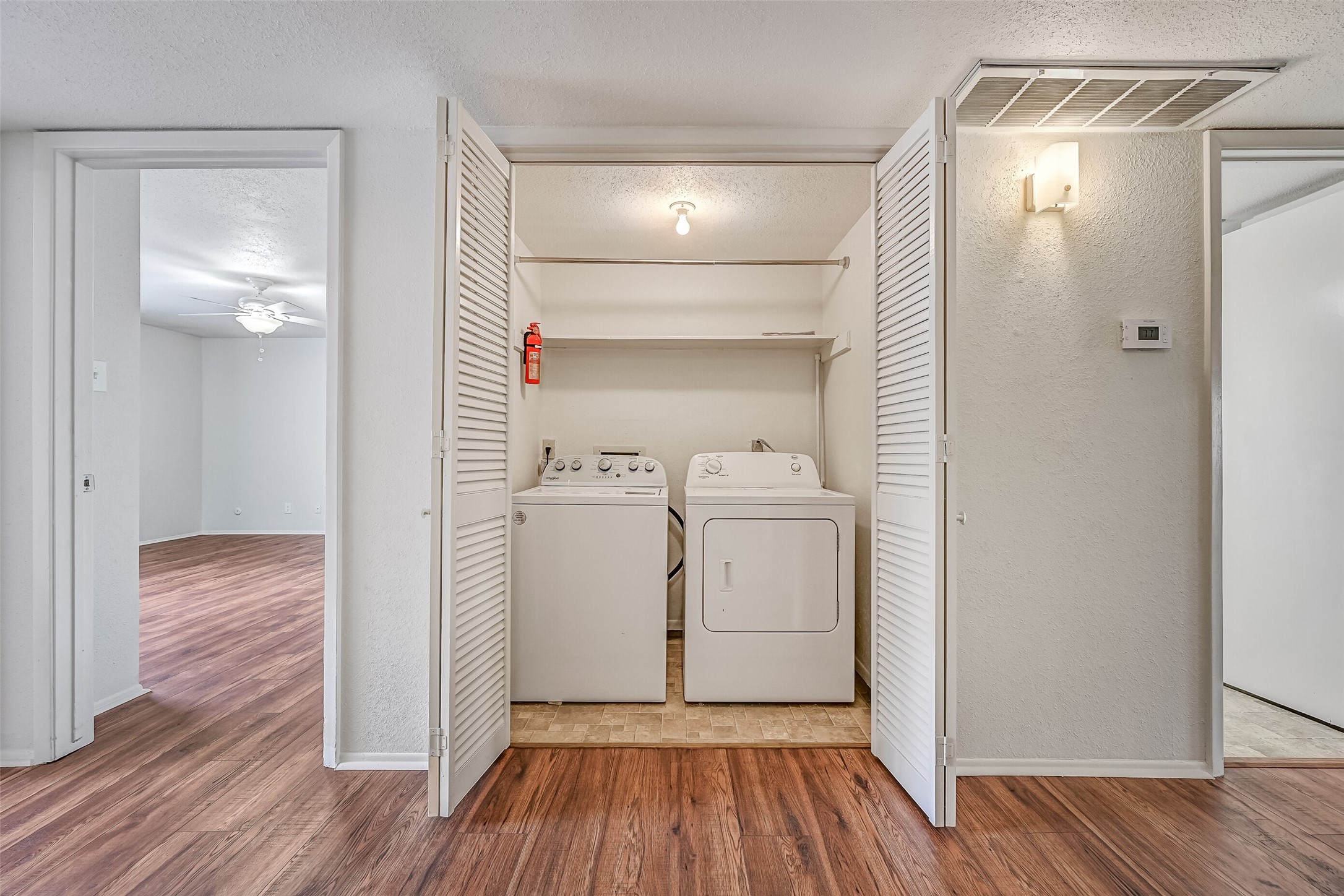A full-size washer & dryer are included with this condo, neatly tucked behind double louvered doors near the entry. Overhead shelving provides additional storage for laundry supplies, while the central location offers easy access from the bedrooms and main living areas. No shared laundry room needed!