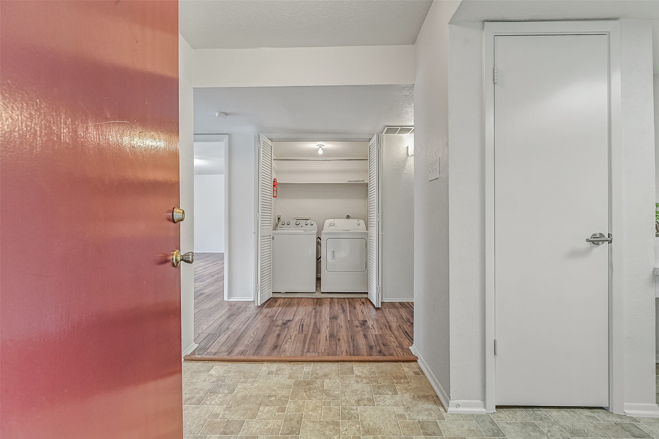 Just inside the front door, you'll find a dedicated laundry closet with a full-size washer & dryer included! Double louvered doors keep the appliances neatly tucked away, while shelving above provides additional storage. Wood-look flooring extends into the adjoining living areas.