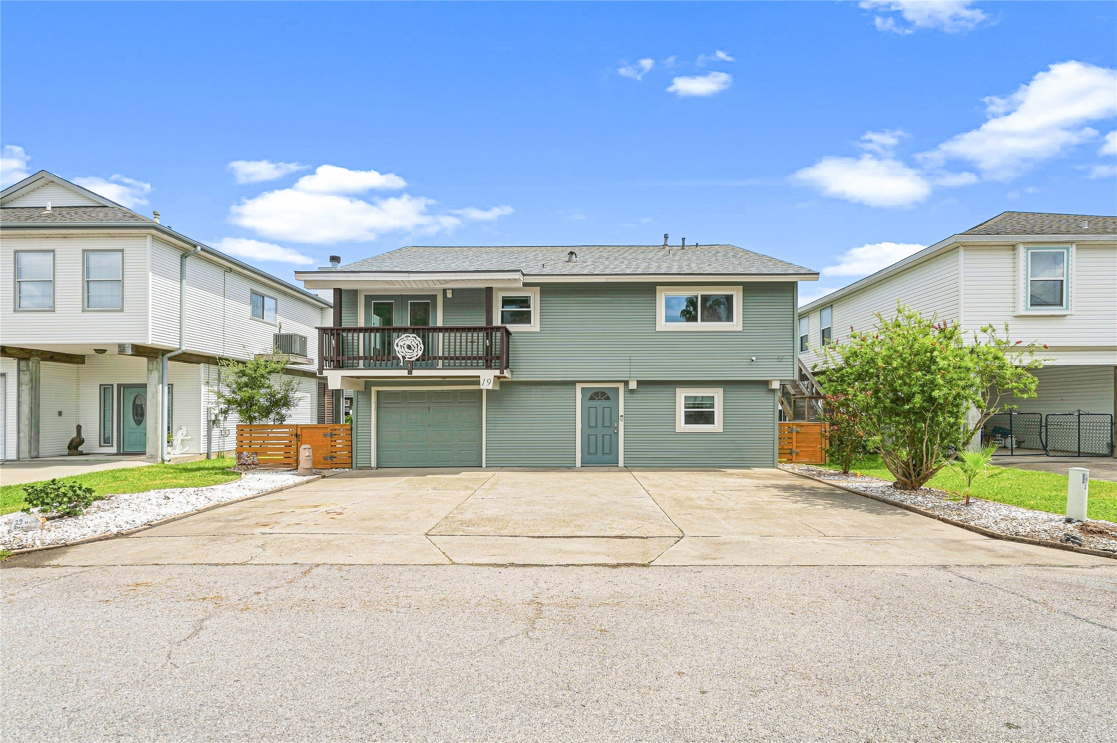 Charming two-story home with a spacious driveway, inviting balcony, and well-maintained landscaping, nestled in a friendly neighborhood.