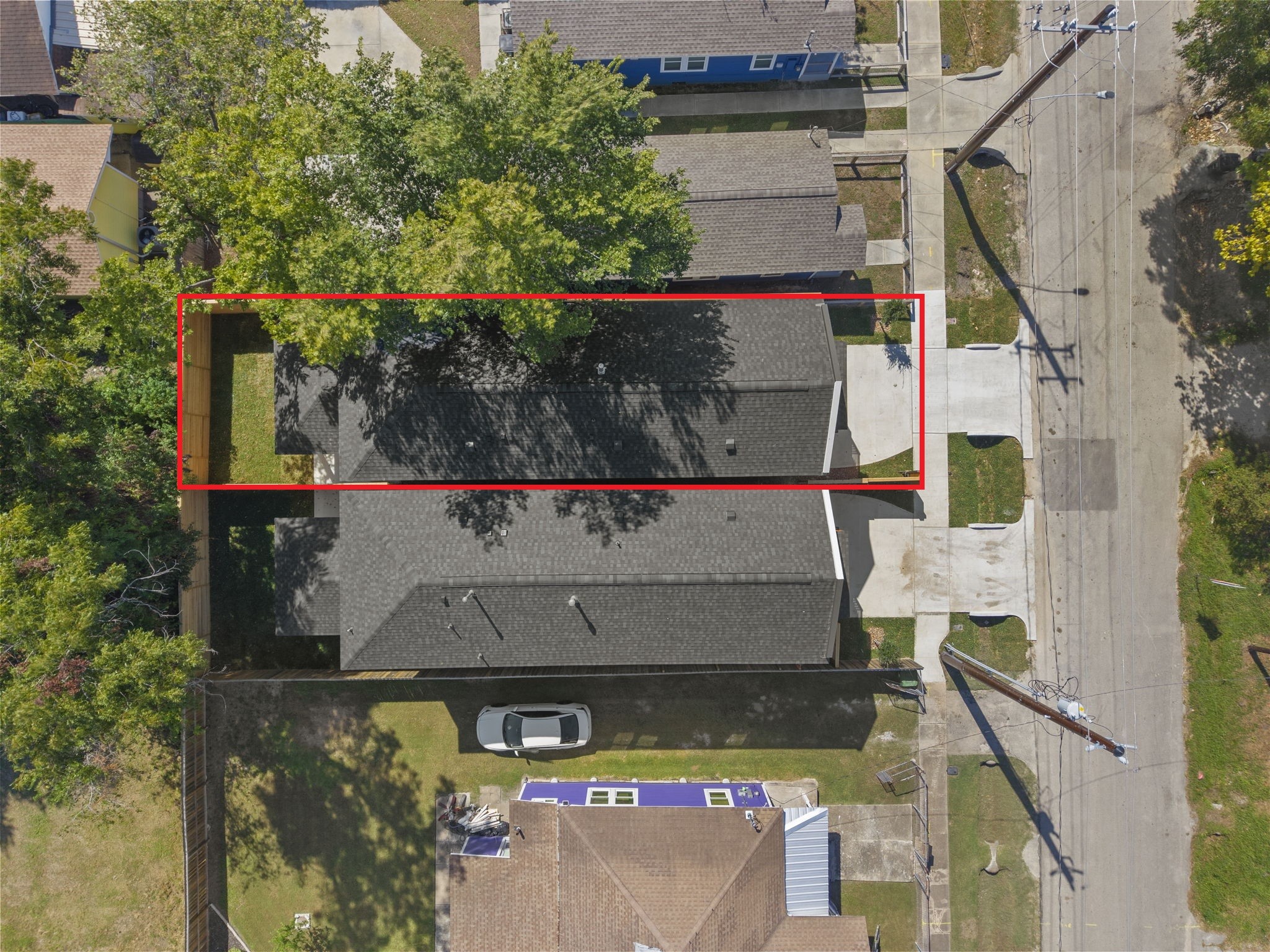 This top-down aerial shot highlights the rectangular property footprint and well-defined site boundaries. The footprint highlights a dedicated front driveway, a streamlined main structure, and a private enclosed backyard set.