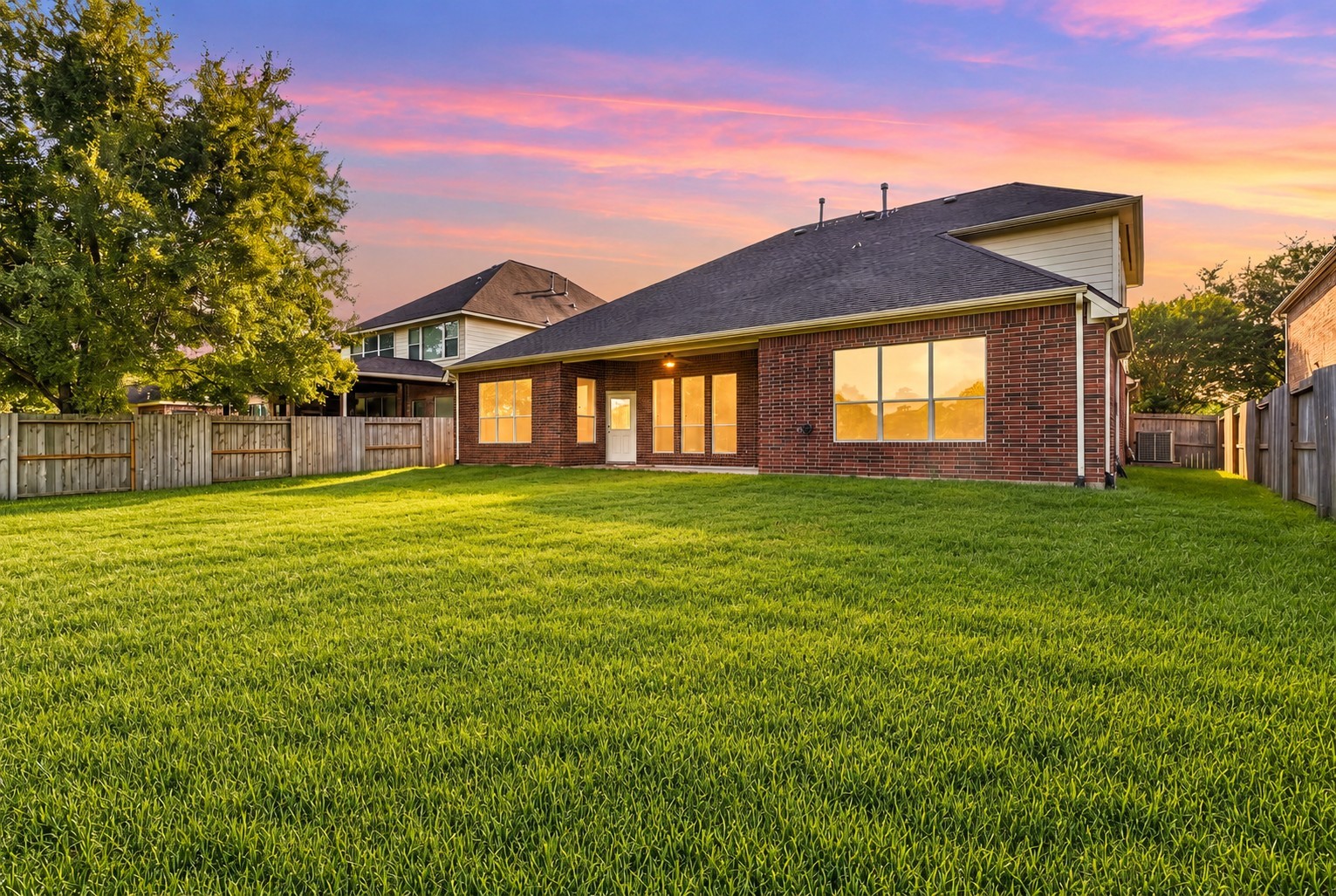 Featuring an impressive lot size with a secure wooden perimeter fence, this property delivers a broad expanse of lush green turf.