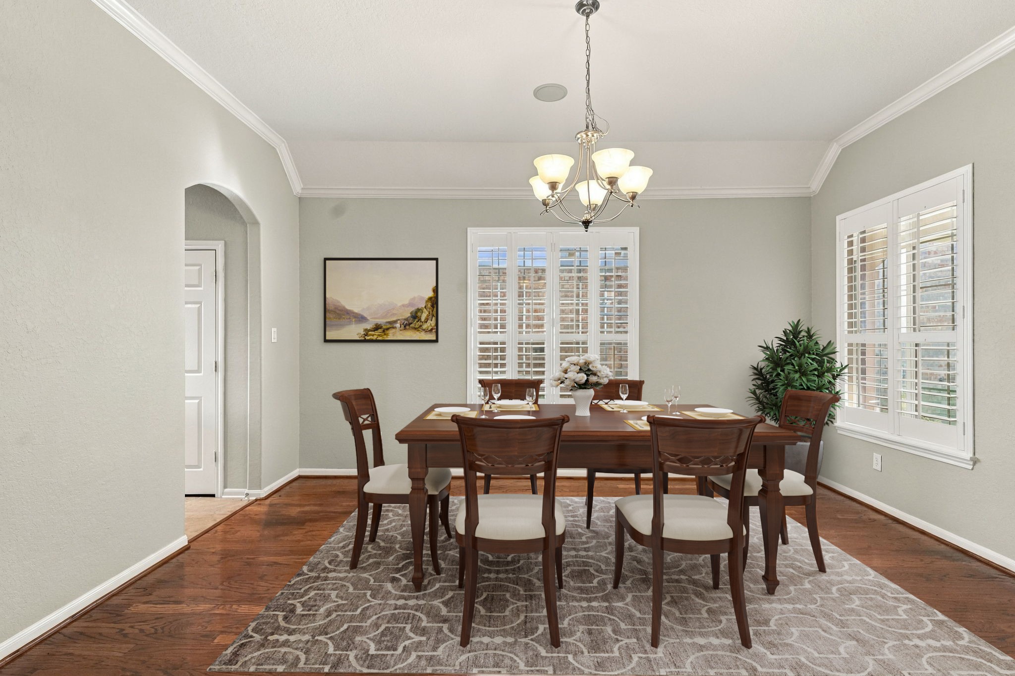Virtually Staged: This elegant formal dining room features tray ceiling detailing, refined crown molding, and a traditional chandelier centered over the space.
