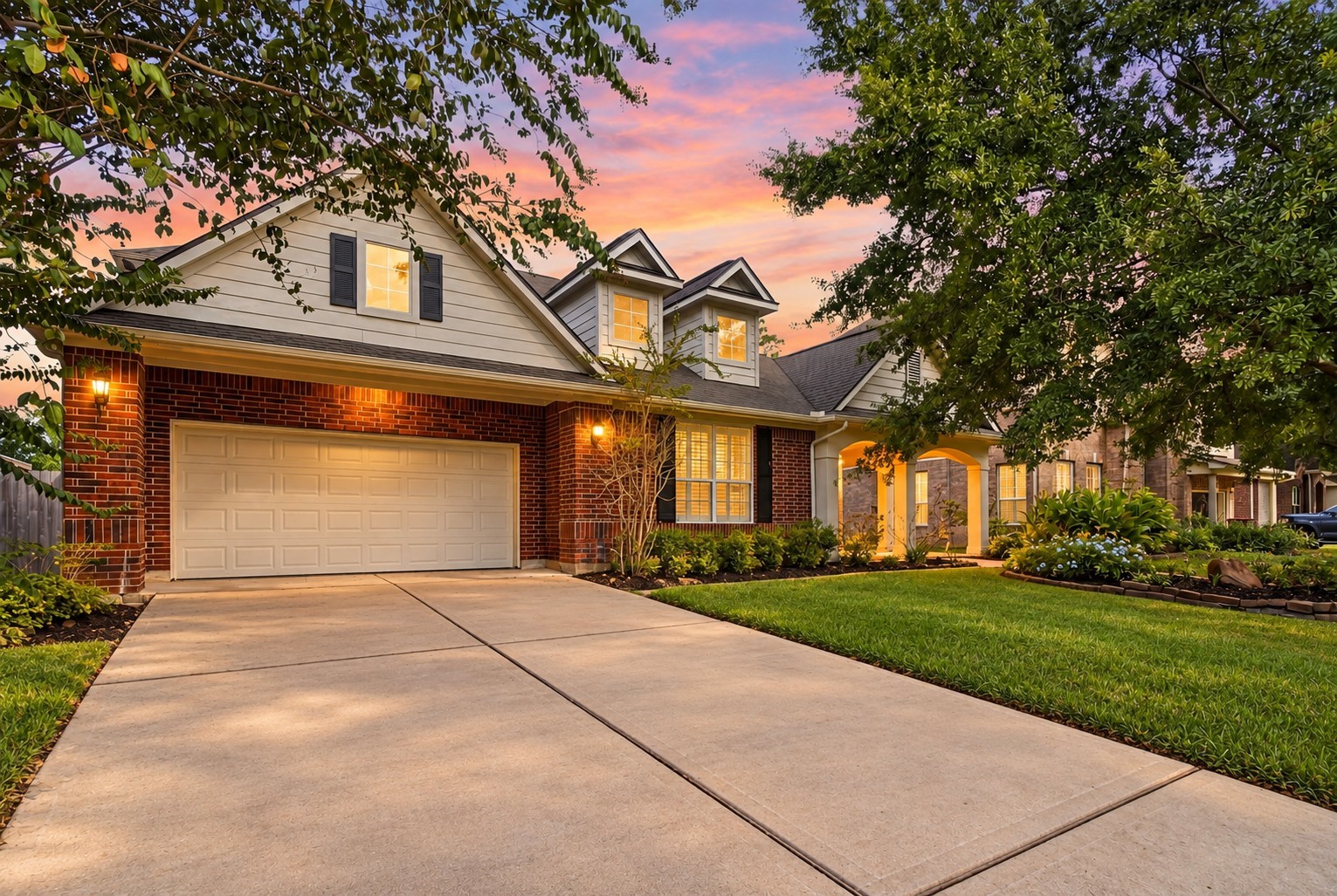 Crafted with timeless appeal, this inviting property welcomes you with rich brick detailing, decorative shutters, and a beautifully lit facade.
