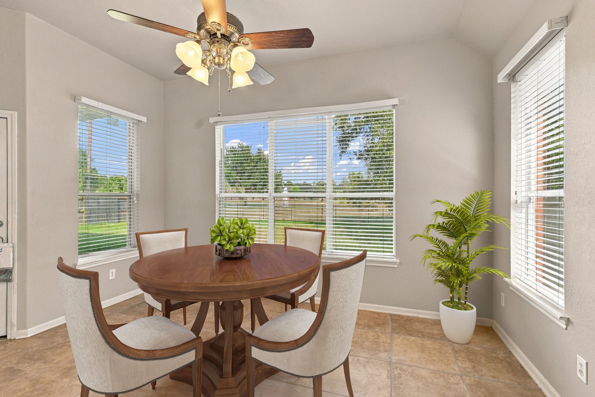 Virtually Staged: This sun-drenched breakfast nook features expansive windows that capture picturesque backyard views while bathing the area in natural light.