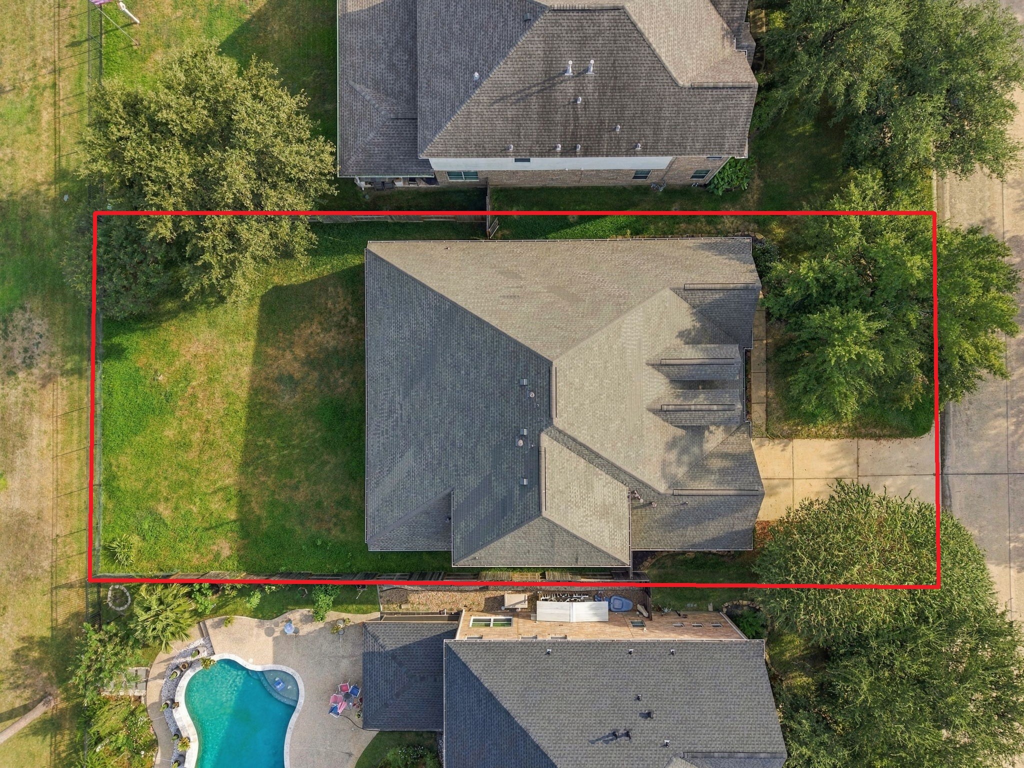 Demonstrating the full layout from above, this shot showcases the home's substantial footprint, multi-gable roof design, and private perimeter boundaries.