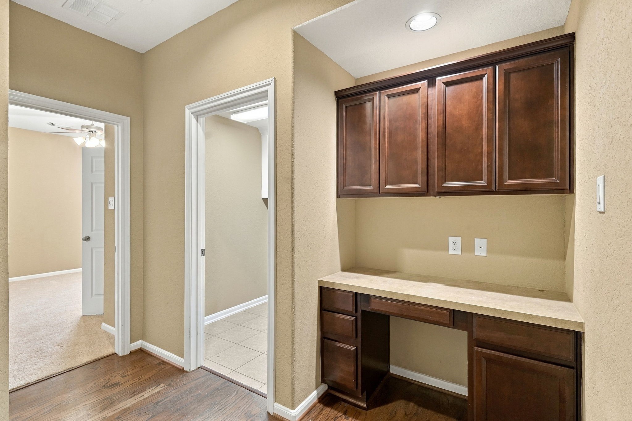 This versatile built-in desk alcove features custom upper cabinetry, lower storage drawers, and an expansive workspace.