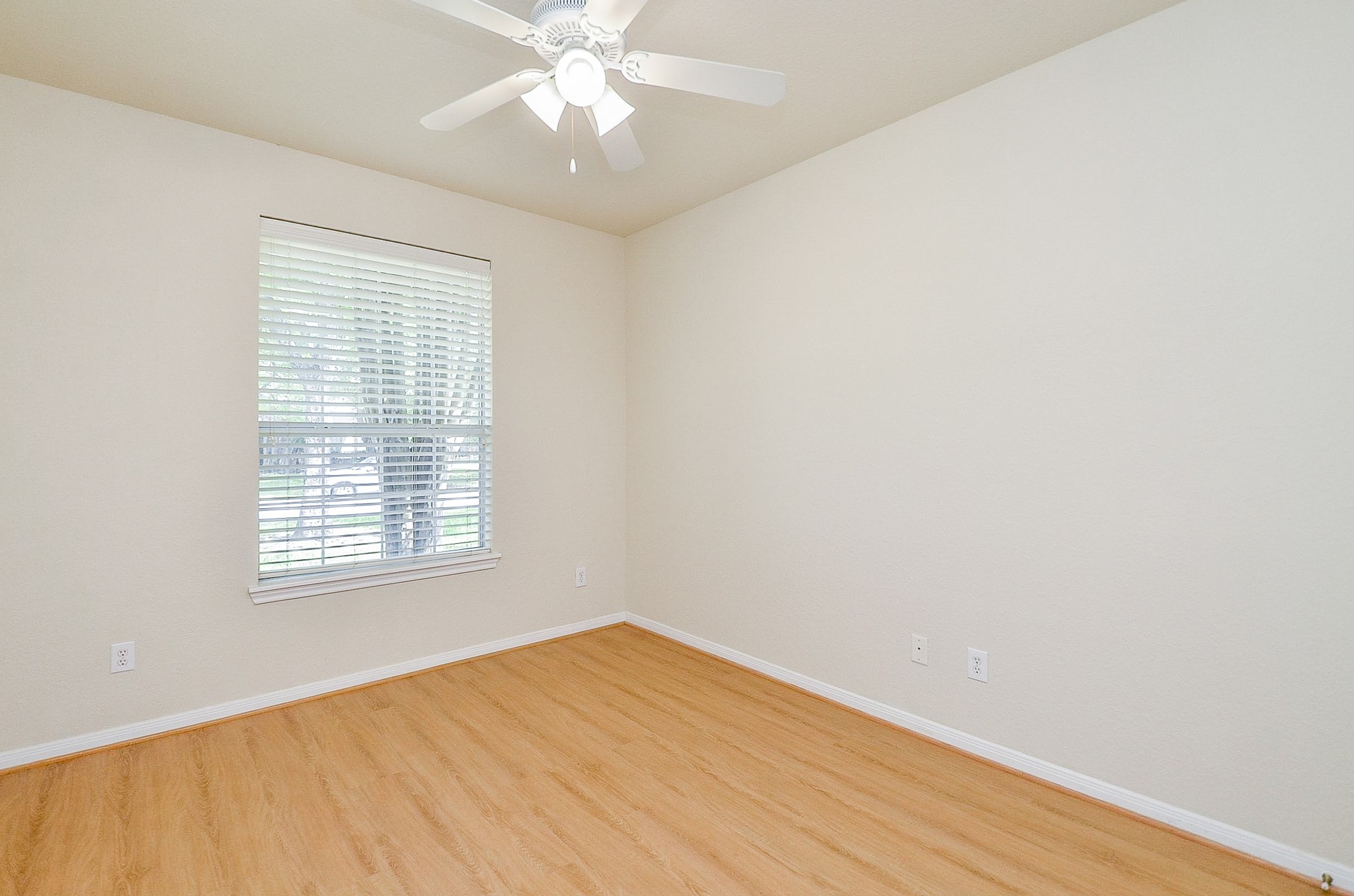 Comfortable room sizes continue beyond the primary suite. This downstairs bedroom offers plenty of space for a full bedroom setup, with new paint and easy-care flooring providing a fresh start.