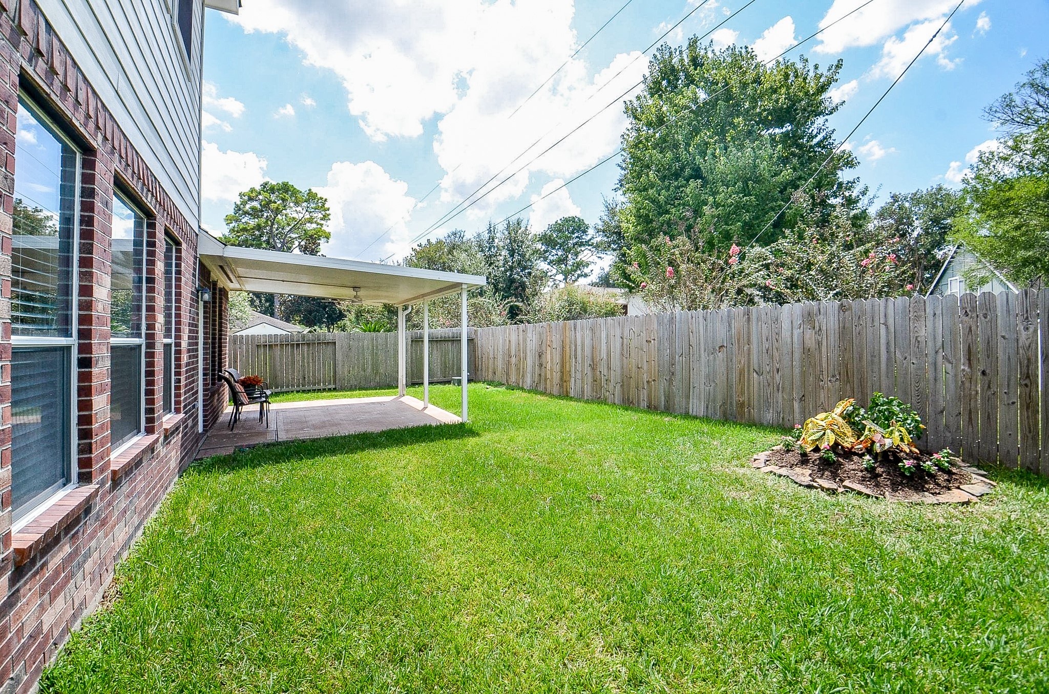 The open lawn offers space for a playset, garden, games with the kids or four-legged family members, while the covered patio gives everyone a shaded place to gather.