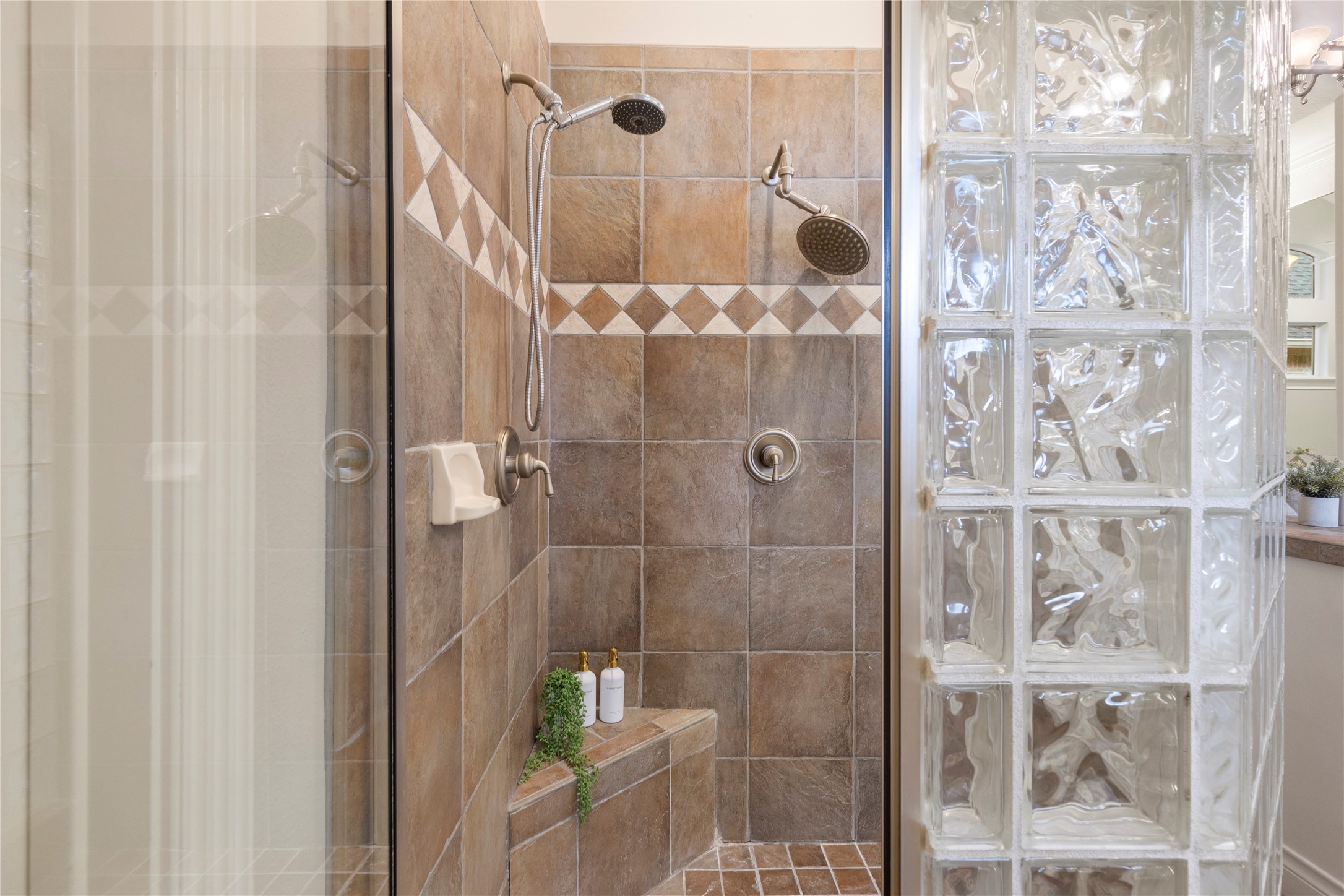 A separate shower with glass block detail adds function and privacy to the primary bath. The layout supports daily ease while preserving the suites sense of retreat.