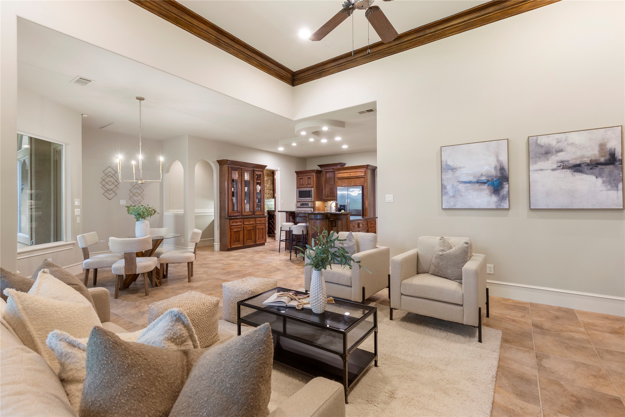 With the ceiling detail, fireplace views, and an open connection to the kitchen, the den is designed for relaxed living without sacrificing presence. Notice the arhced walkway behind the builtin, that leads to an alcove desk space.