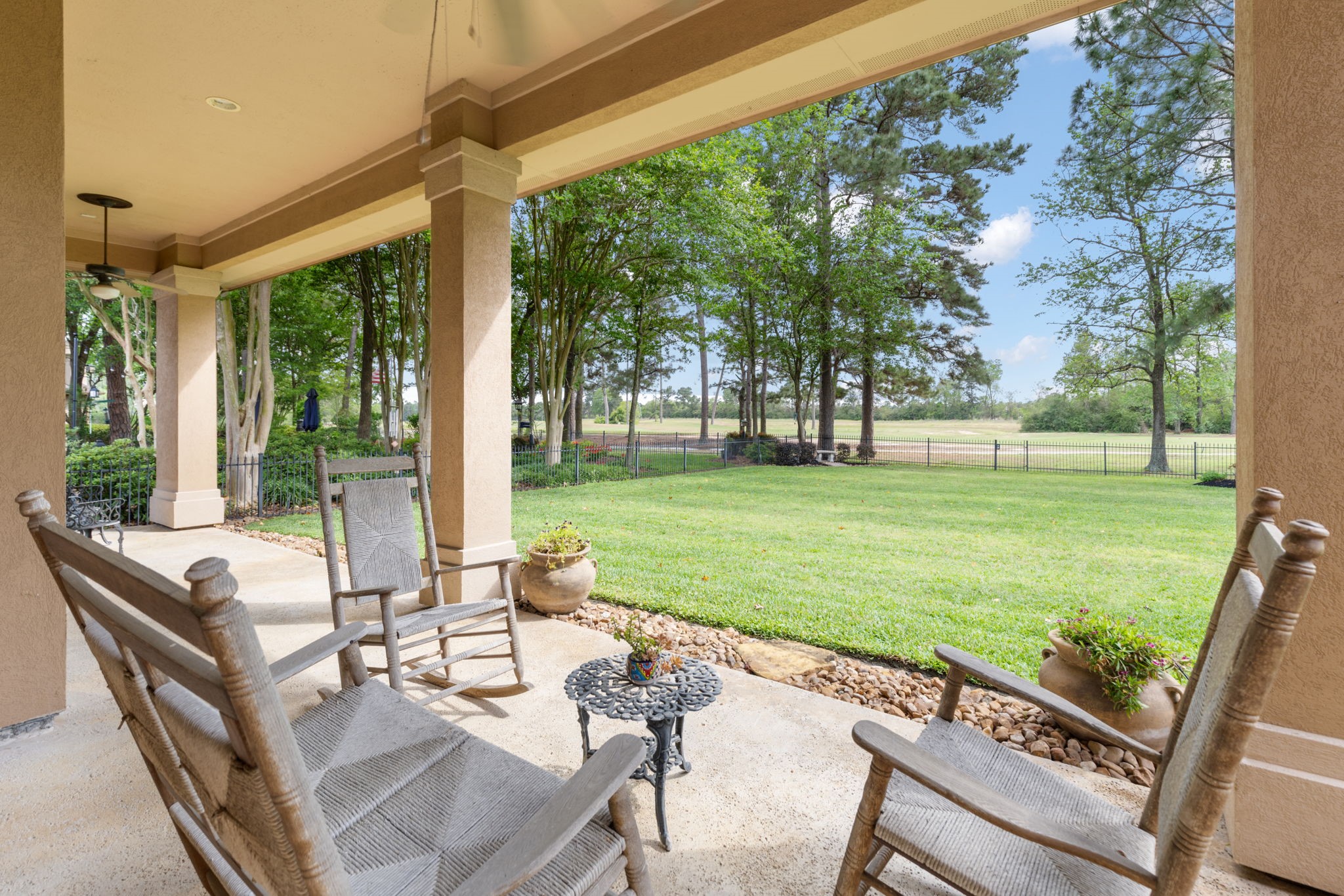 The covered patio extends the living space outdoors with a direct view across the lawn and golf course. Sunset views from this area are a standout part of the homes lifestyle.