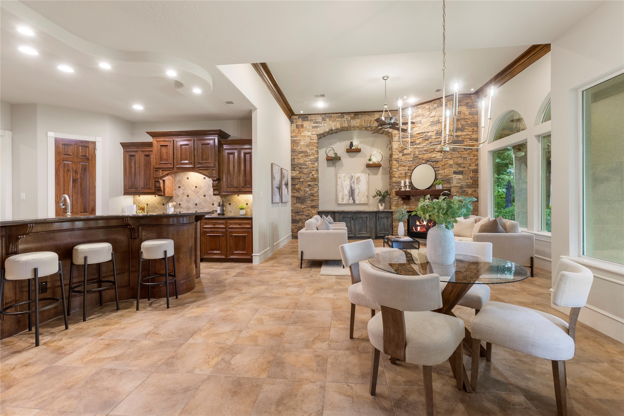 The kitchen flows directly into the den, allowing the heart of the home to function beautifully for gatherings and daily routines. Large windows keep the outdoor views present throughout the main living area.