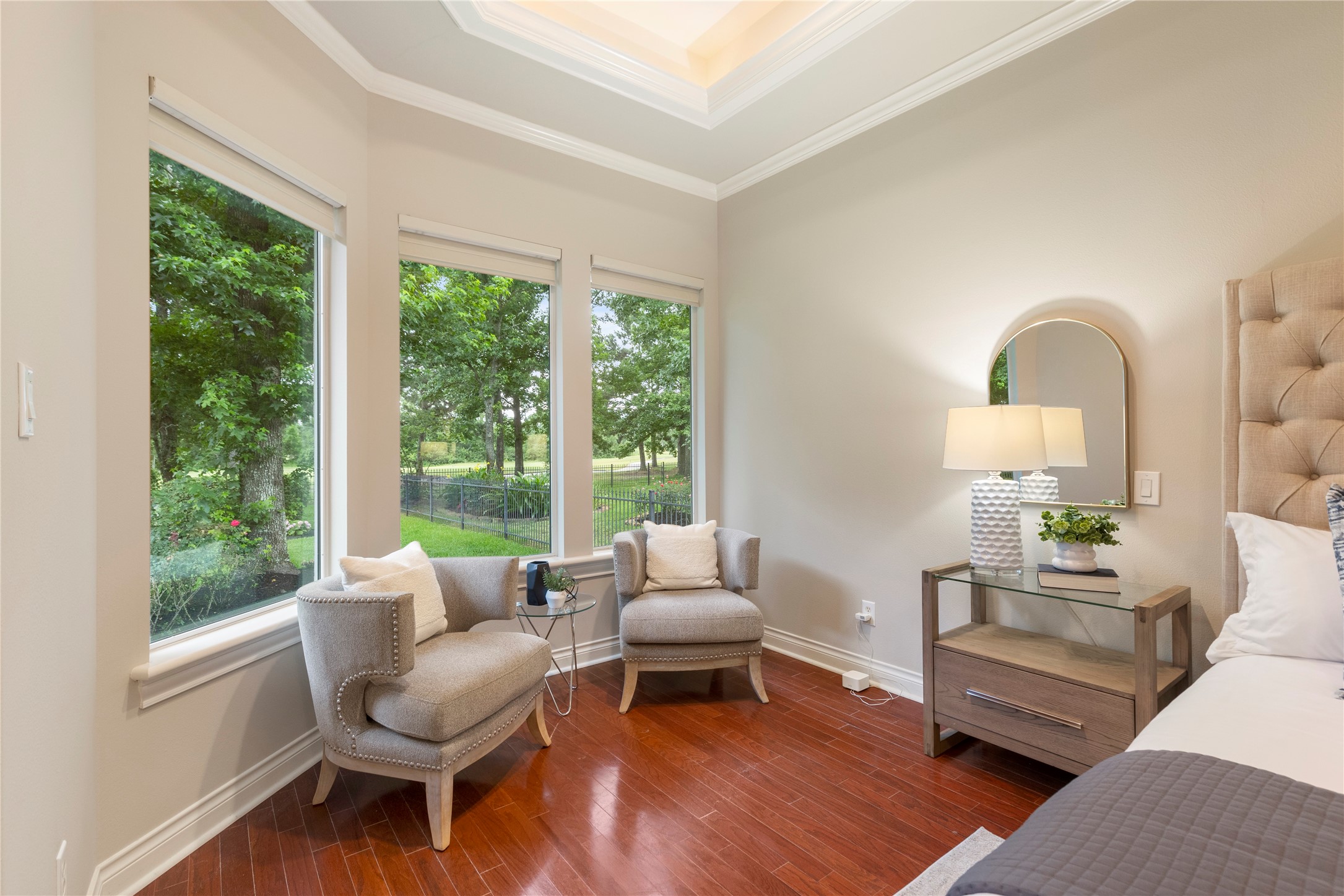 A sitting area surrounded by large windows captures expansive views of the backyard and golf course. The placement offers a peaceful vantage point over the double fairway setting.