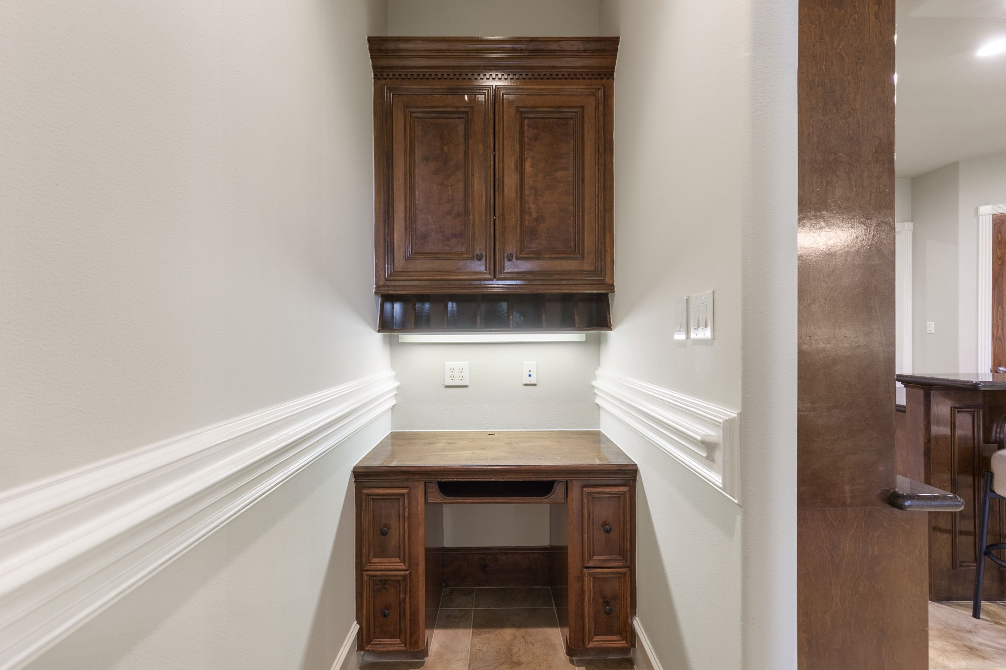 A dedicated desk space near the kitchen adds practical storage and prep space for everyday convenience. This thoughtful detail supports the needs of a busy household.