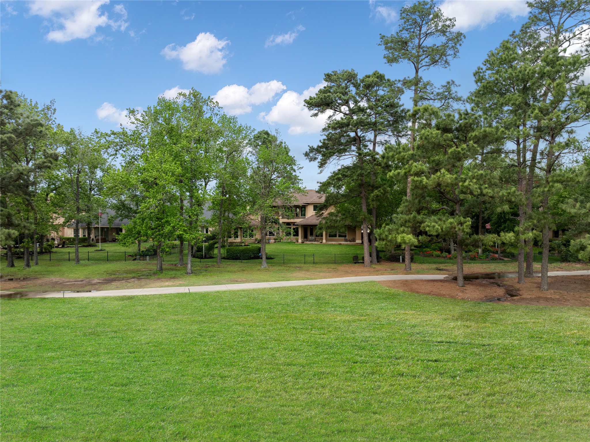 From the lawn, the depth of the lot and tree lined golf course setting become clear. This outdoor space offers a rare combination of openness, privacy, and established surroundings.