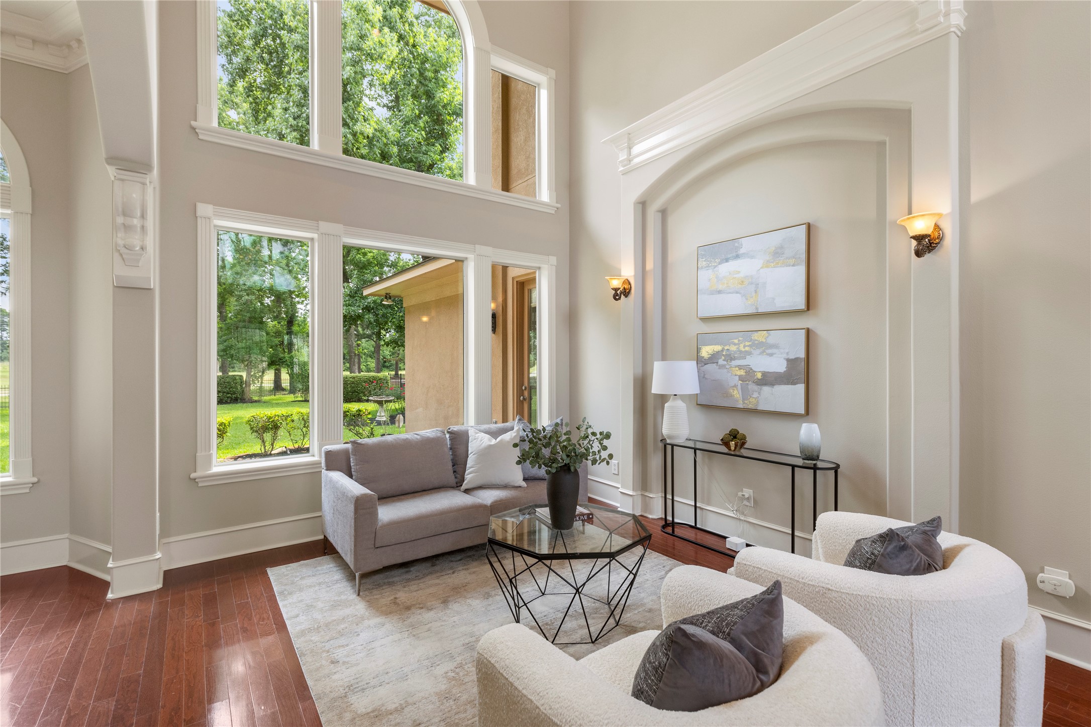 Tall windows bring natural light into the formal living area while showcasing calming views of the backyard and golf course. This space offers an elegant setting for conversation, entertaining, or quiet moments at home. Tall windows bring natural light into the formal living area while showcasing calming views of the backyard and golf course. This space offers an elegant setting for conversation, entertaining, or quiet moments at home.