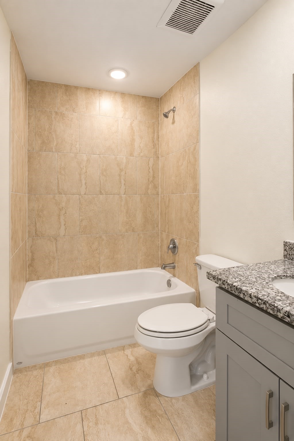 Full bathroom with tiled tub and shower combo and vanity storage.