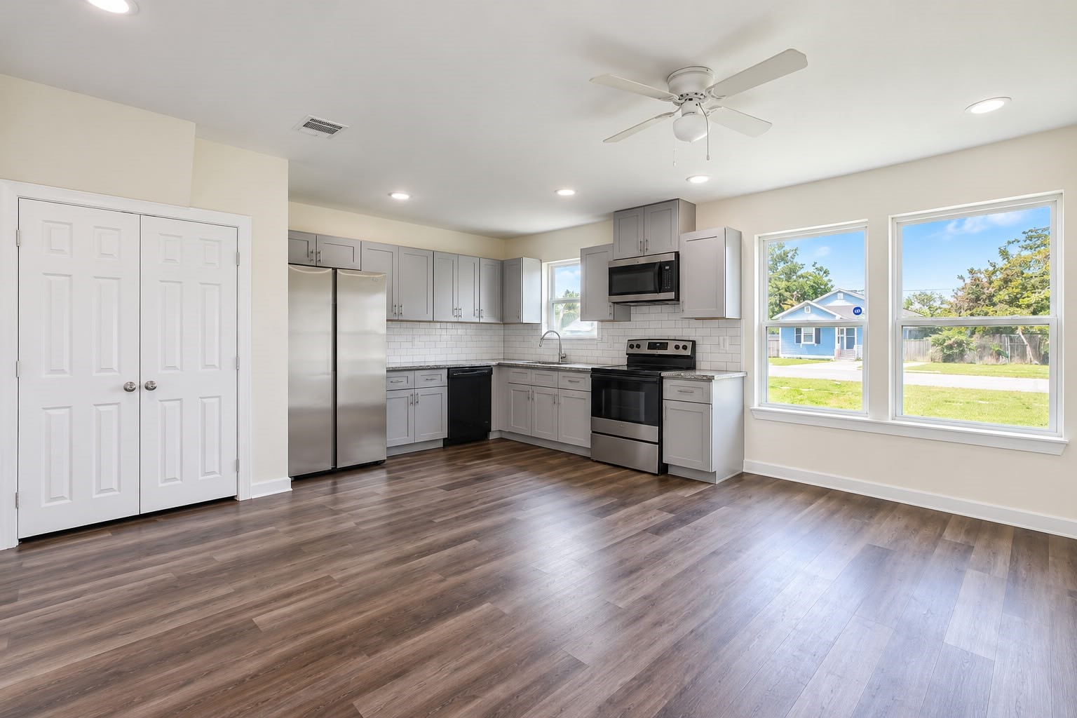 Open concept living and kitchen with wood style floors, recessed lighting, ceiling fan, and lots of natural light.
