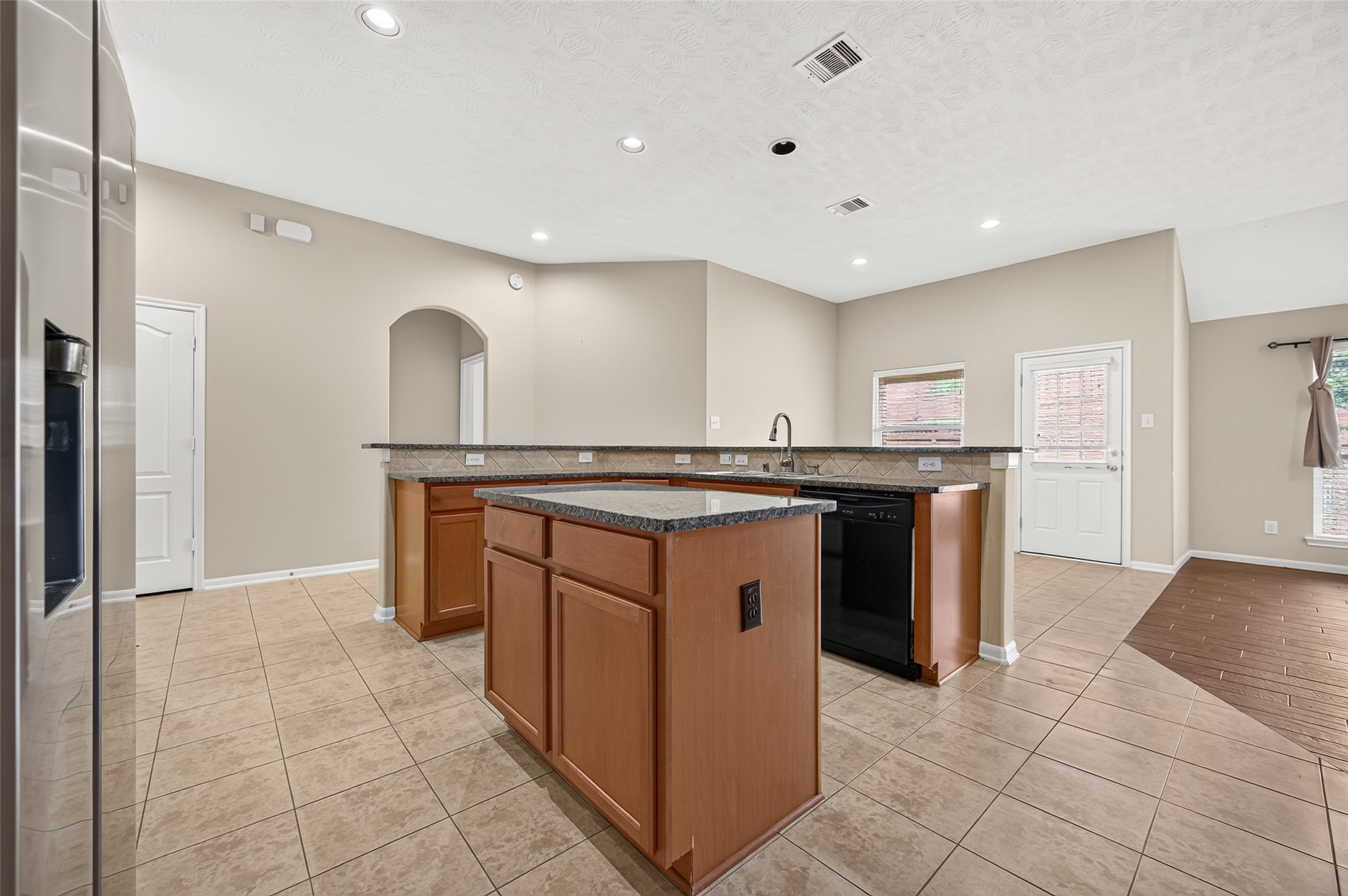 Additional kitchen view highlighting the center island, extensive cabinetry, and adjoining dining area.