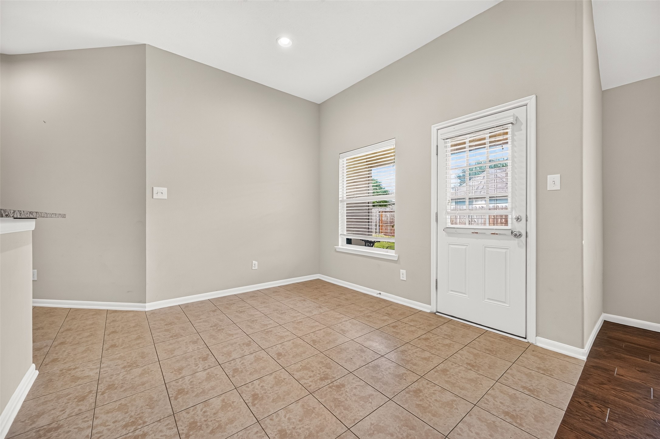 Breakfast area featuring neutral tile flooring, arched architectural details, and an open layout connecting to the kitchen.