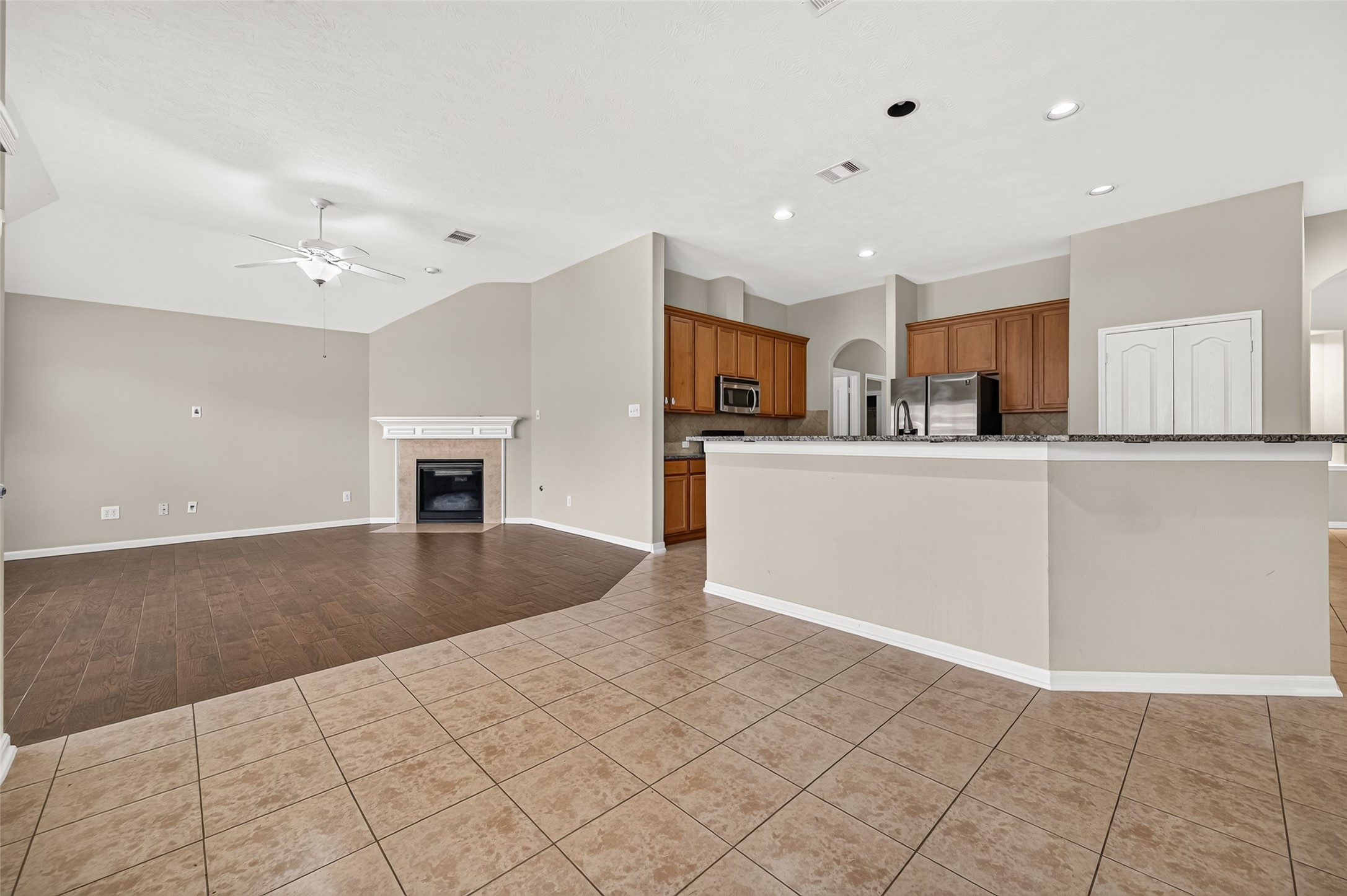 Spacious breakfast area showcasing tile flooring, recessed lighting, and a seamless connection to the kitchen and living room.