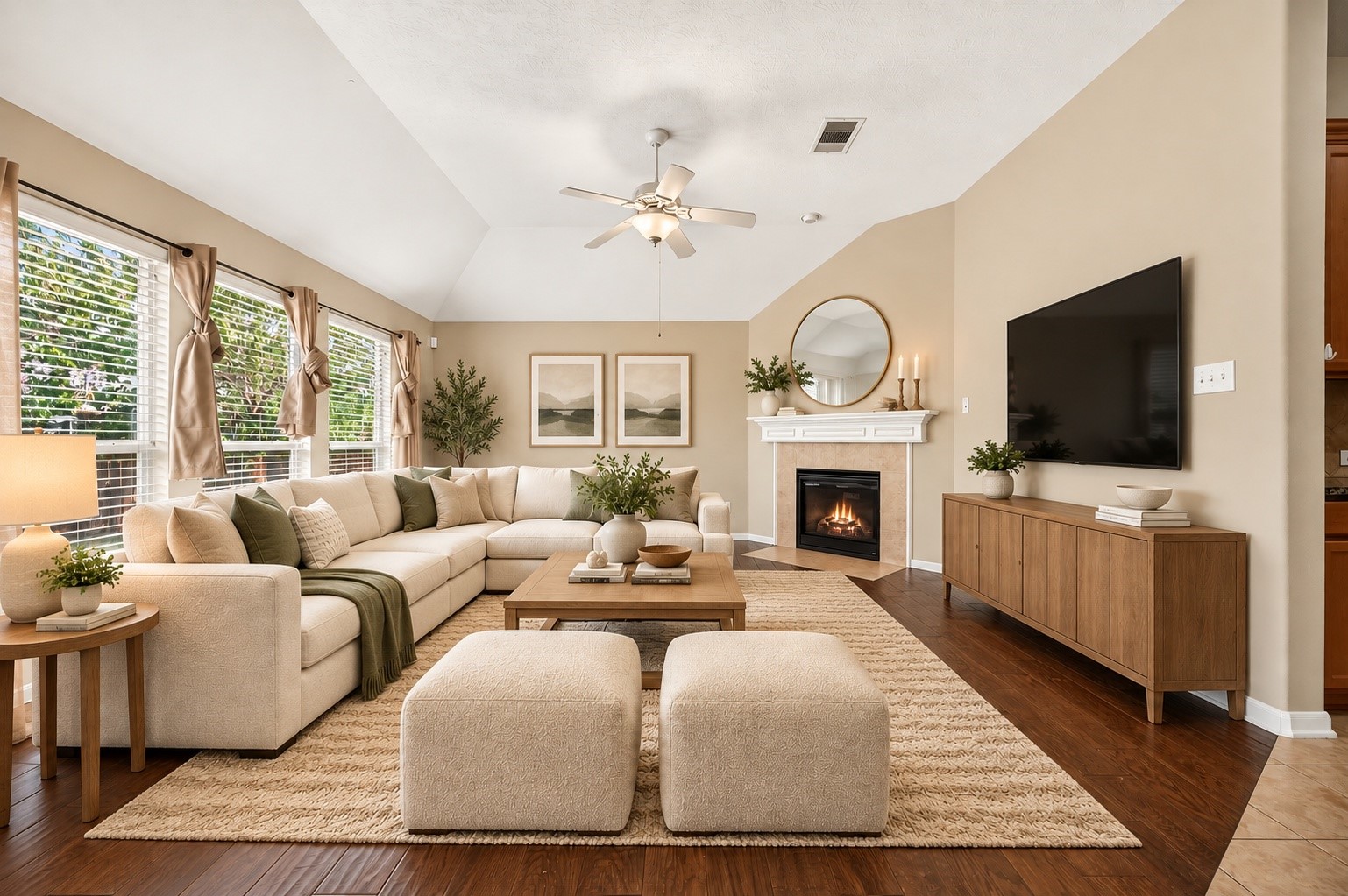 Virtually staged living room featuring vaulted ceilings, rich wood-look flooring, abundant natural light, and a fireplace.