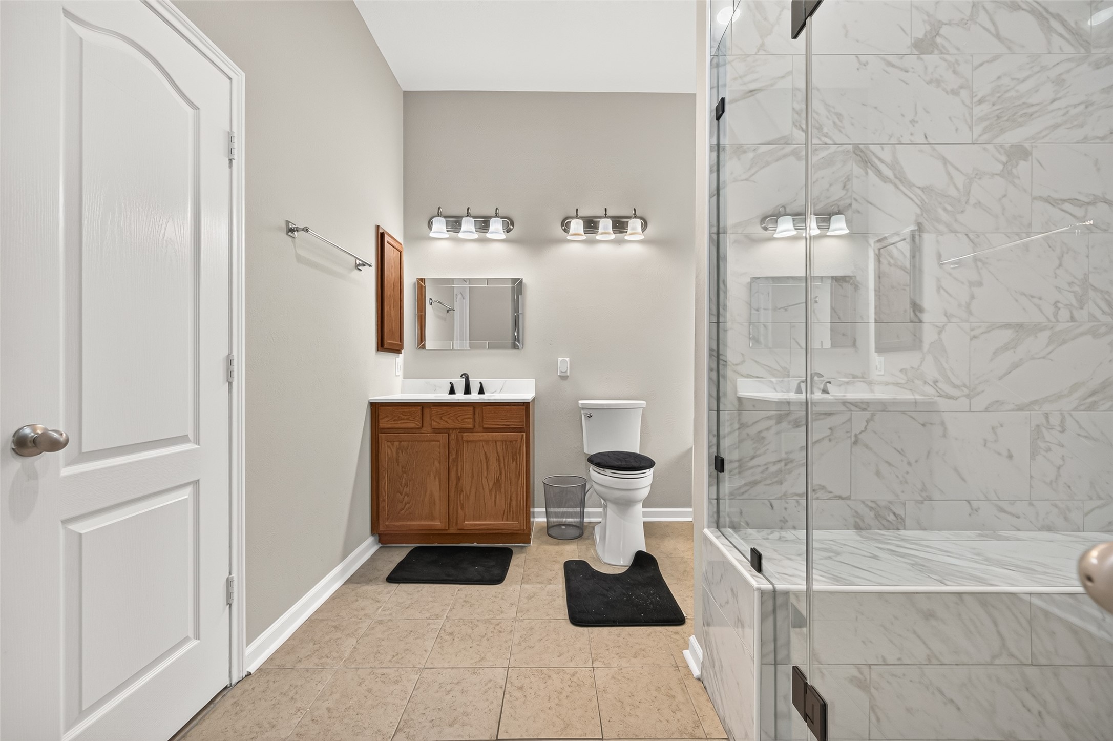 Primary bathroom featuring a separate soaking tub, glass-enclosed shower, and decorative tile finishes.