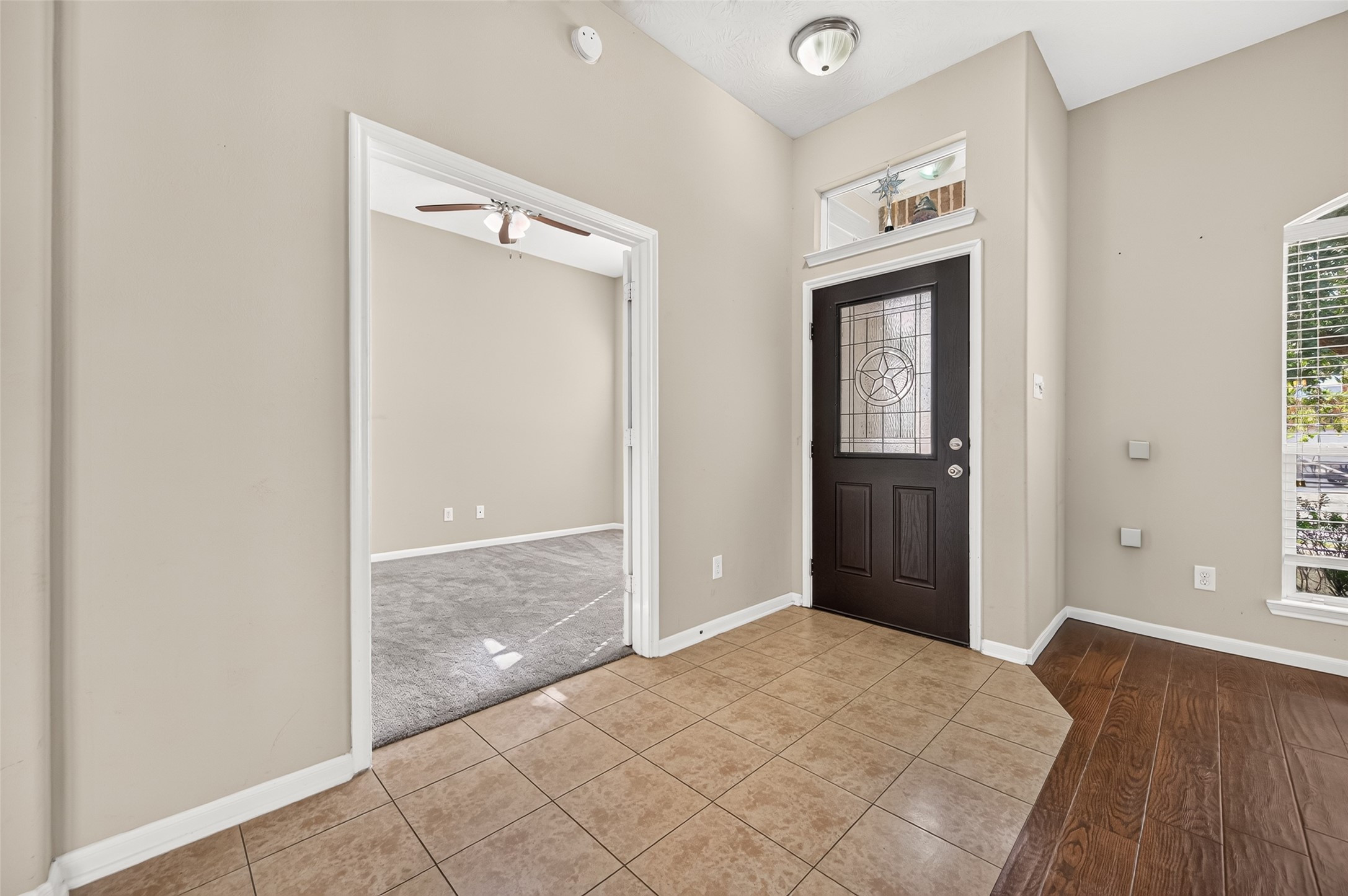 Additional view of the entryway highlighting the decorative arches, natural light, and open layout.