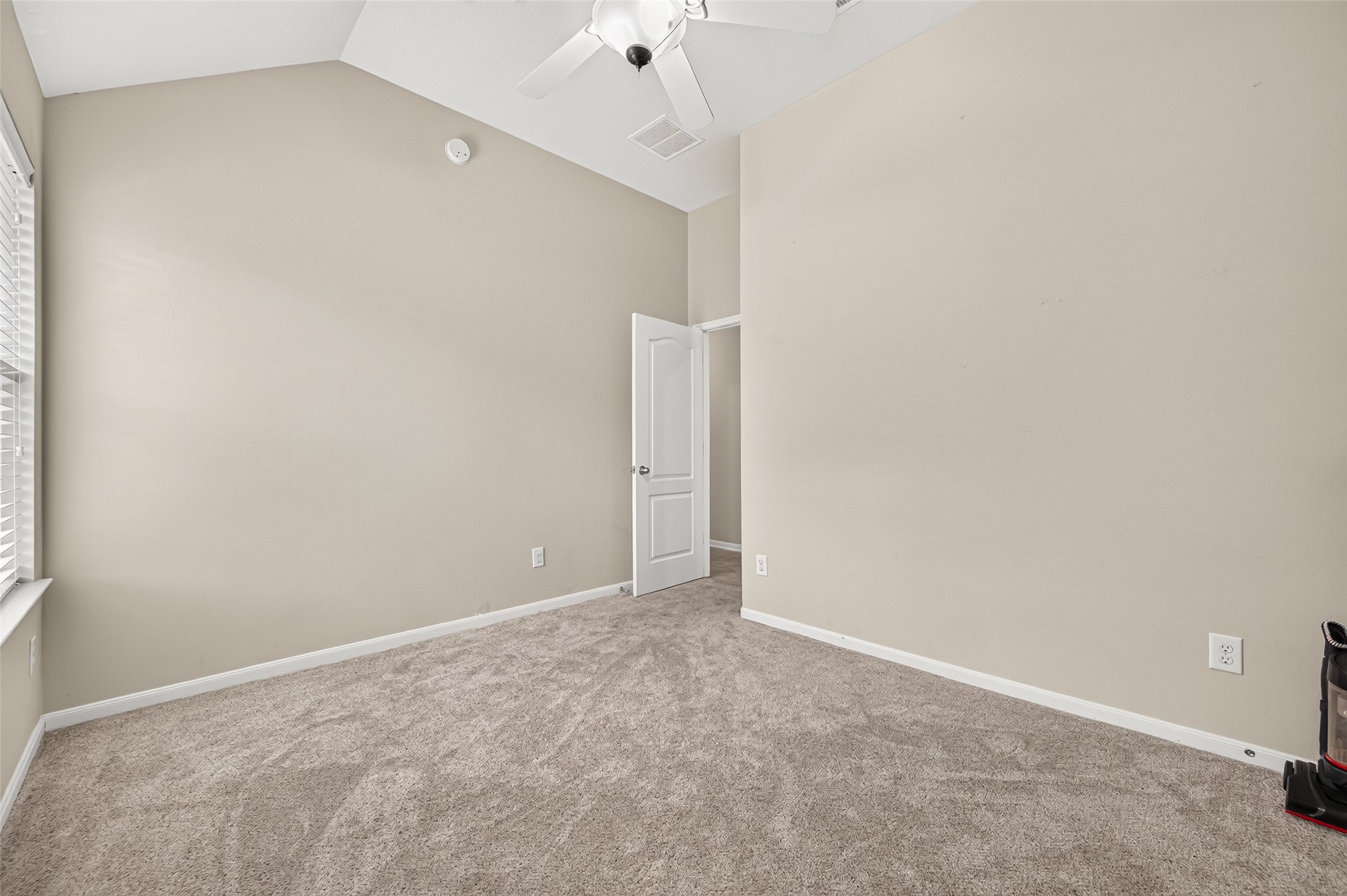 Additional secondary bedroom view showcasing the ceiling fan, closet doors, and natural light.