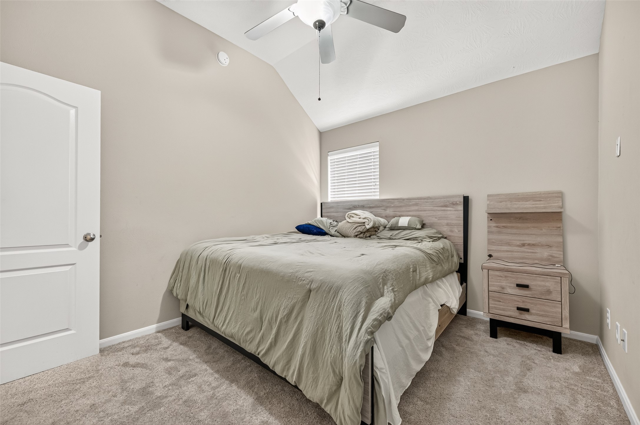 Another view of the secondary bedroom highlighting the neutral walls, carpeting, and closet access.