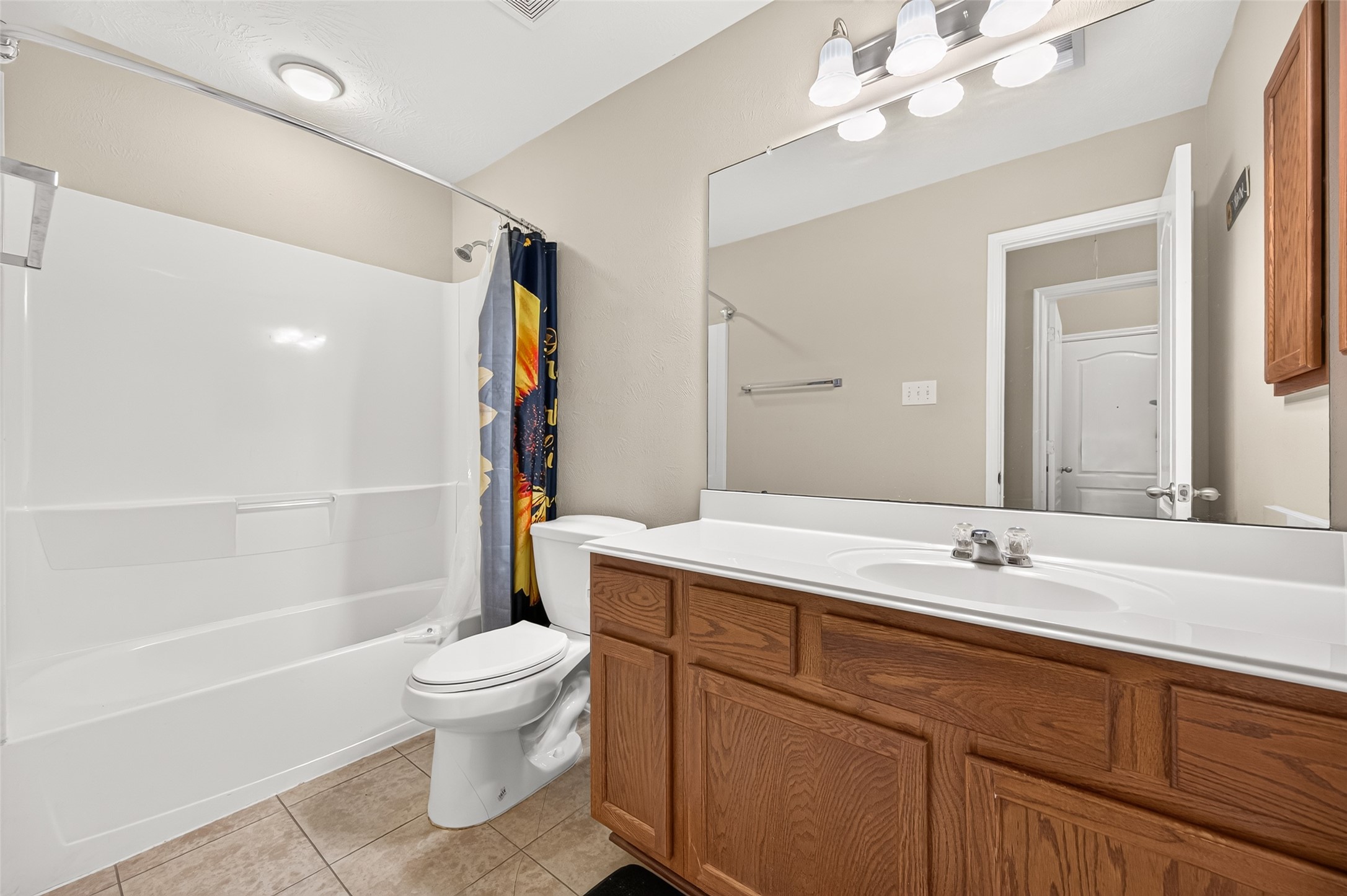 Secondary bathroom featuring a tub and shower combination, vanity, and neutral finishes.