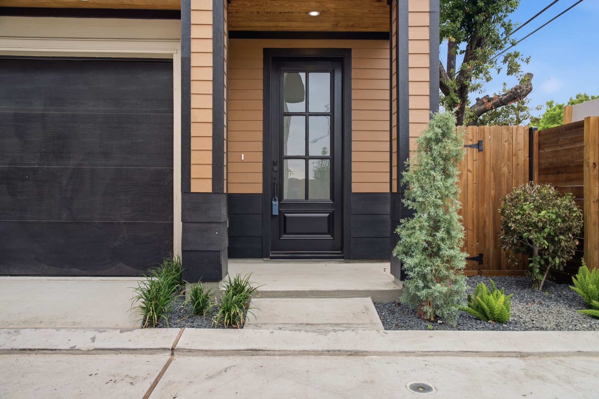 Front entryway into the home featuring a porch and side fence with acces to the private guest suite.