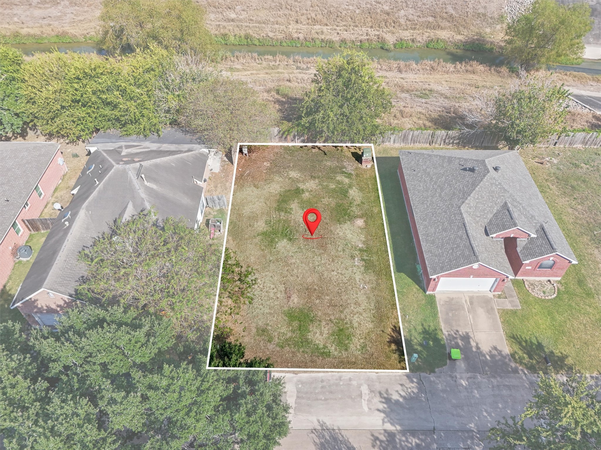 Your Dream Home Starts Here! The white outline highlights this spacious, cleared residential lot nestled between established homes. Imagine designing your custom dream home with room for outdoor living, a backyard retreat, and entertaining. Enjoy the charm of an established neighborhood with a greenbelt and waterway beyond the rear property line. A wonderful opportunity to build a home that fits your lifestyle!