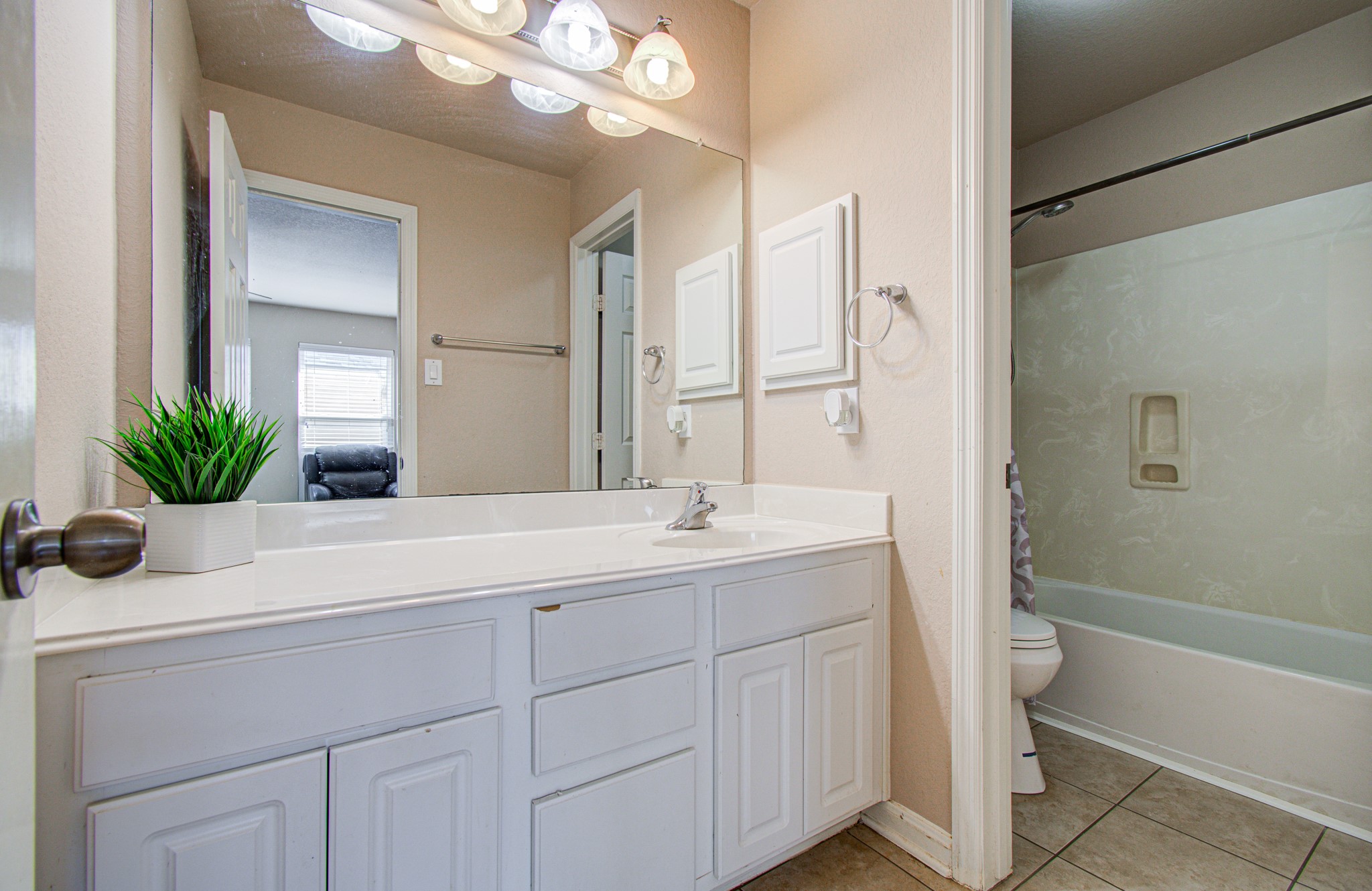 A conveniently located shared bathroom serves the two secondary bedrooms upstairs, providing practical functionality for household members and overnight guests. Its central location complements the home's flexible upper-level layout and supports everyday comfort and convenience.