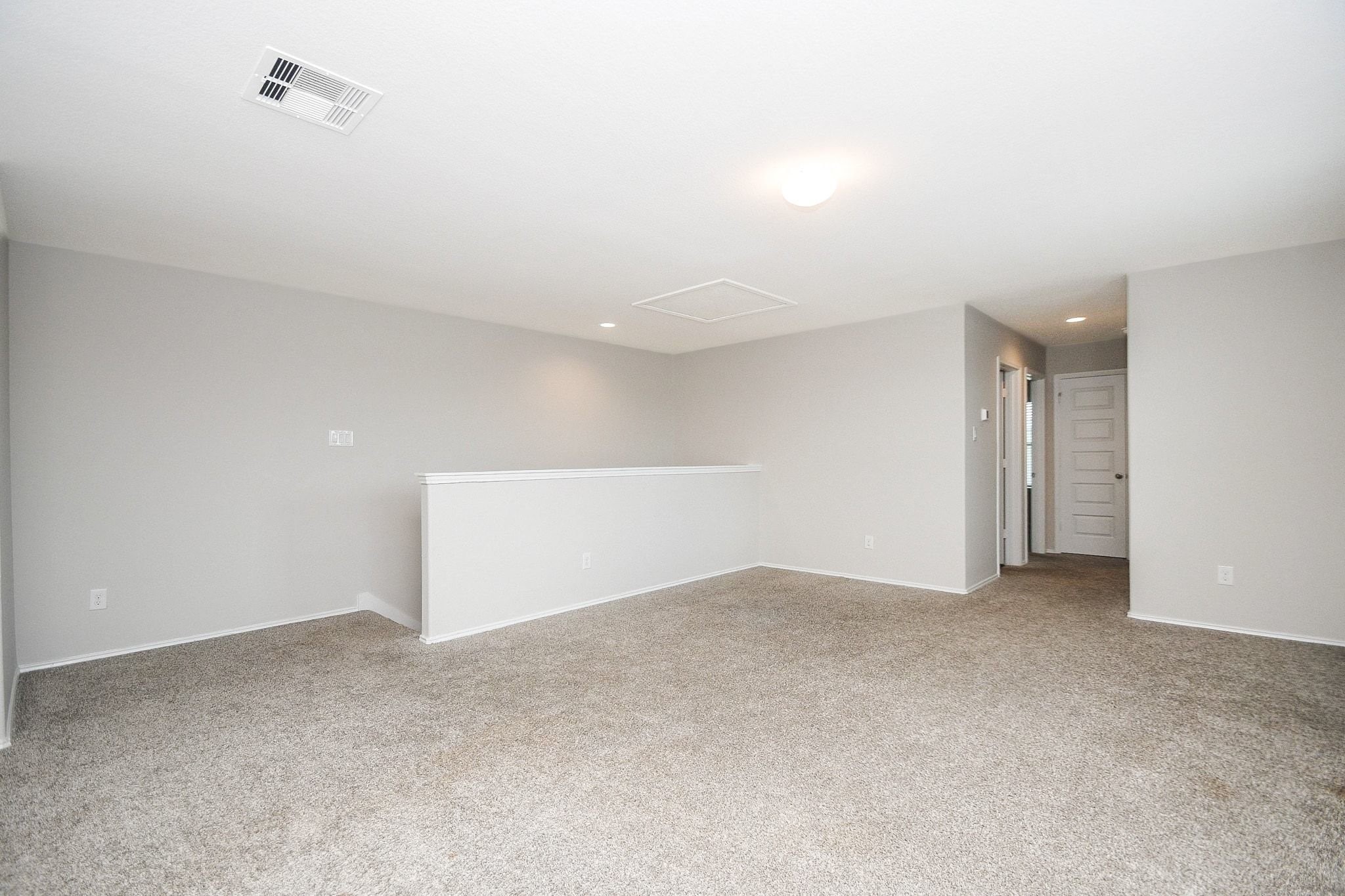 Spacious and bright, Gameroom upstairs featuring plush carpeting and neutral tones, perfect for a versatile living area or additional bedroom.