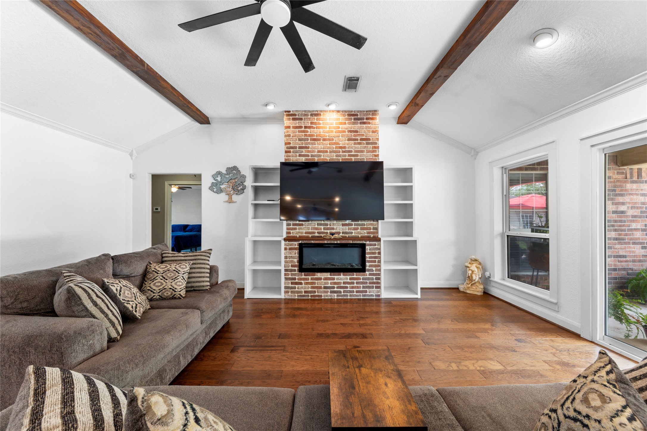 Glass fireplace and wood beams creates a great living space