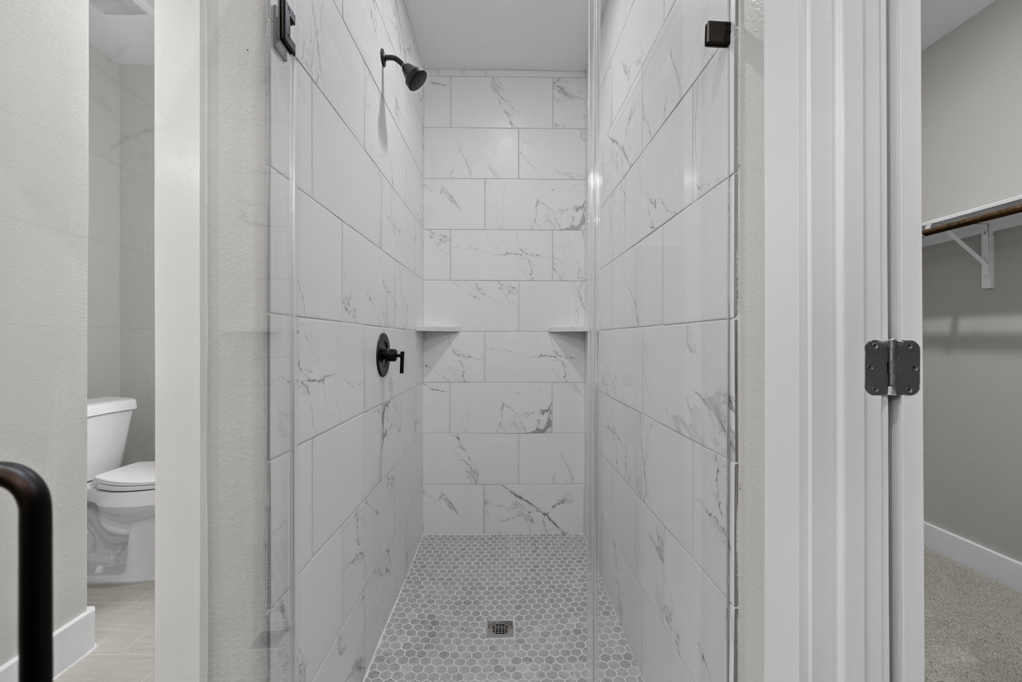 Primary Bath Shower with floor to ceiling tile and frameless door