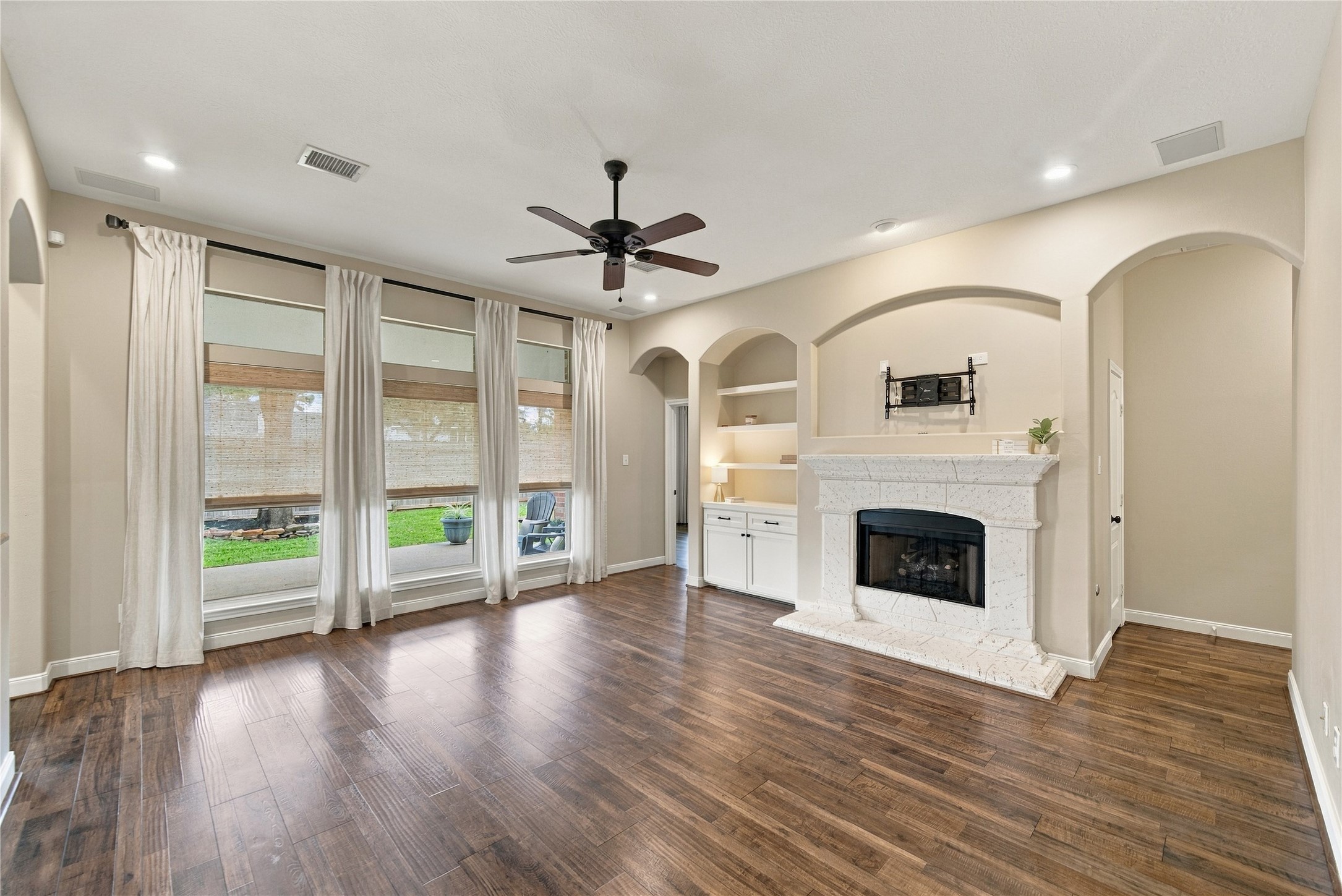 Step into this beautiful family room and you'll be impressed by its spaciousness, rich wood-look floors, elegant arched openings, built-in shelving, and inviting gas fireplace. What an attractive space for relaxing or spending time with family and friends! Step into this beautiful family room and you'll be impressed by its spaciousness, rich wood-look floors, elegant arched openings, built-in shelving, and inviting gas fireplace. What an attractive space for relaxing or spending time with family and friends!